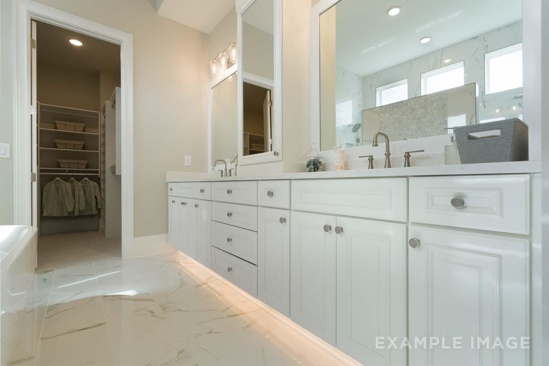Luxurious master bathroom in The Seaside by Davidson Homes featuring double vanities, freestanding tub, and walk-in closet