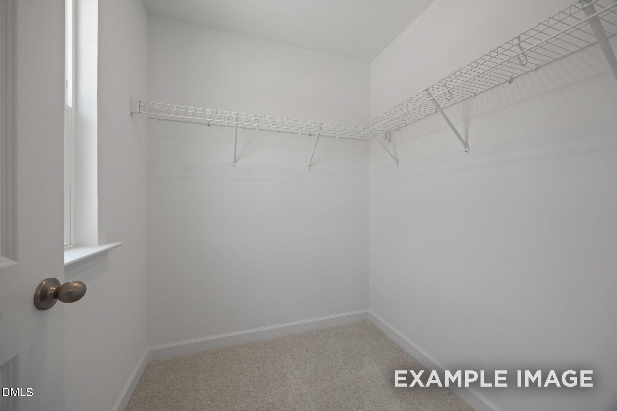 Spacious walk-in closet with wire shelving and carpet in Davidson Homes The Beech floor plan at Wendell Ridge, North Carolina