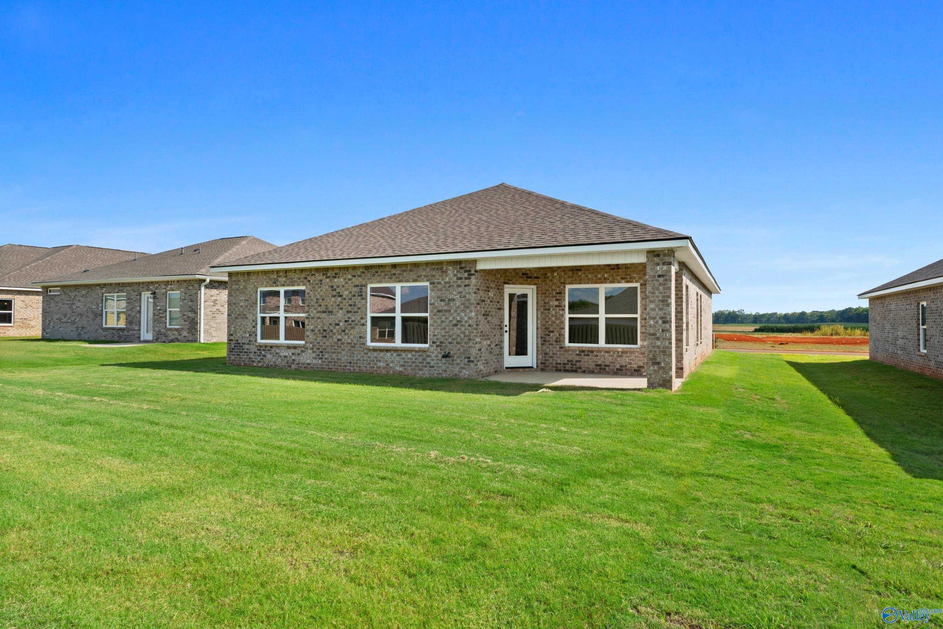 Single-story brick home with gabled roof, windows, and covered entry on lush green lawn in Clearview, Hazel Green, Alabama
