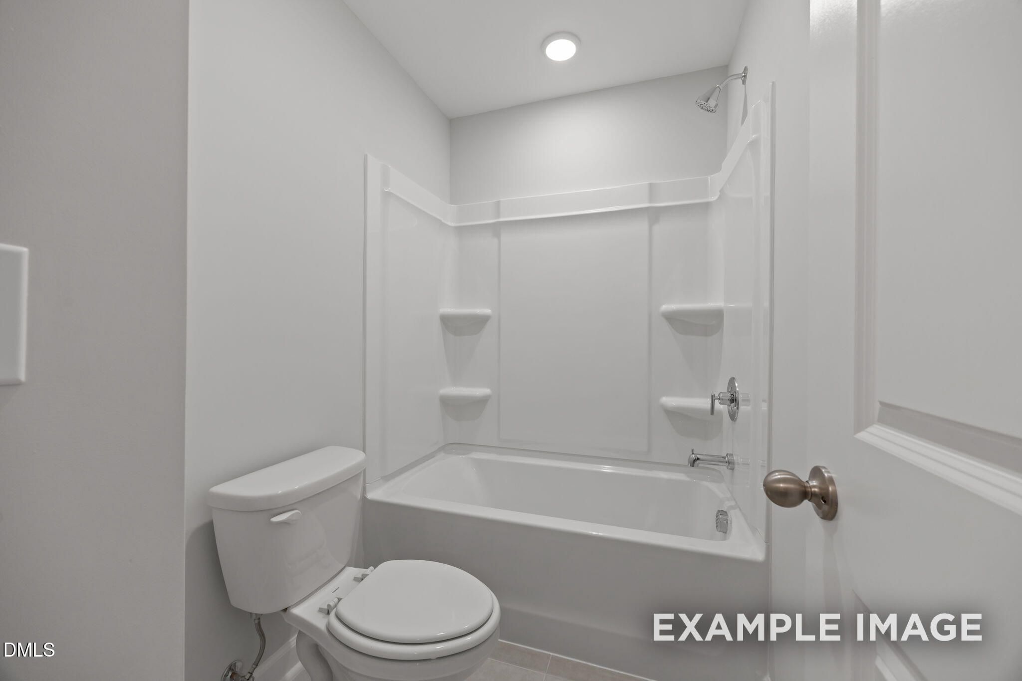 Bright white bathroom with tub-shower combo and corner shelves in Davidson Homes The Beech floor plan, Wendell Ridge, NC
