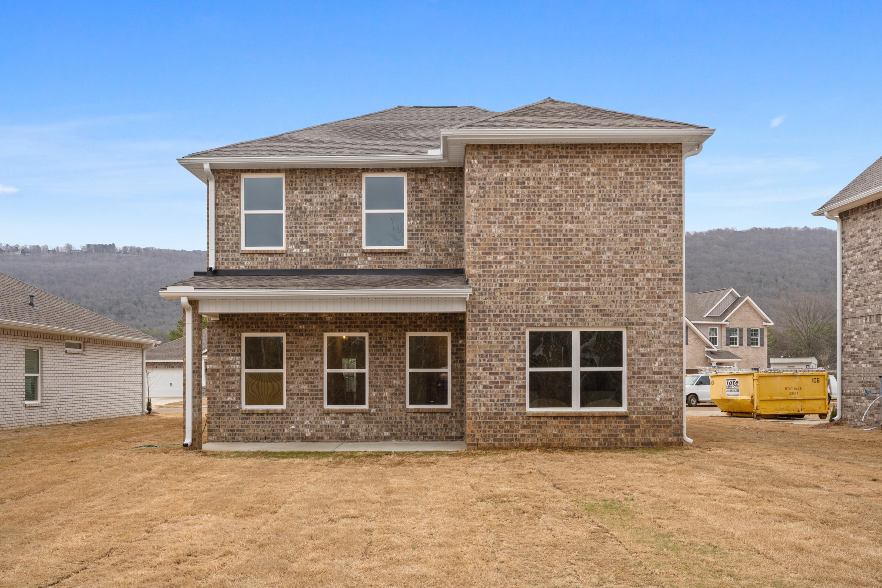 Two-story brick Aiken home elevation with gabled roof, large windows, and covered patio by Davidson Homes in Meridianville, Alabama