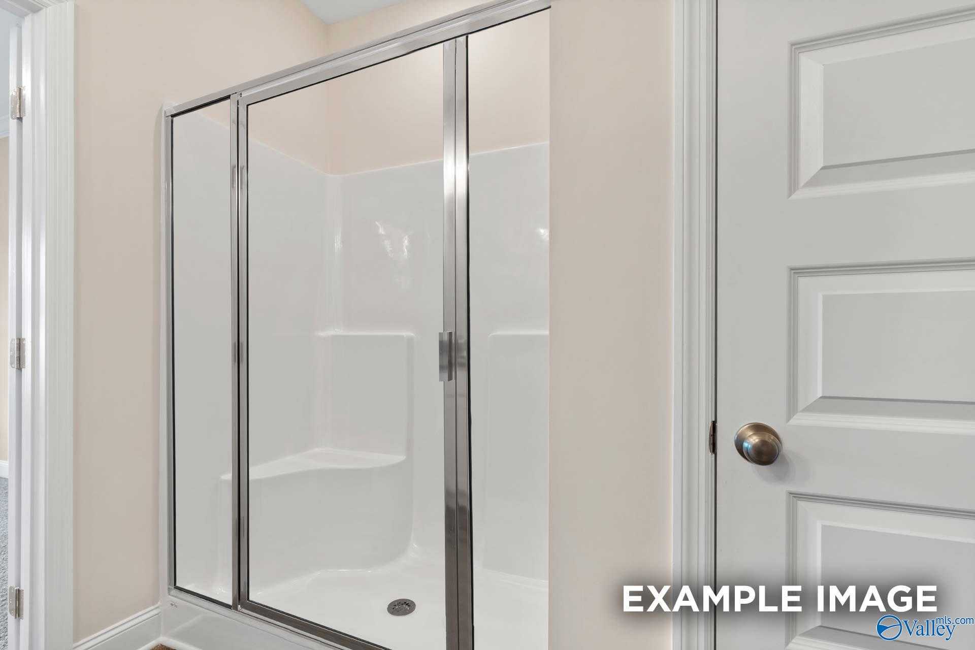 Modern glass-enclosed walk-in shower with bench seat in The Asheville floor plan bathroom, Davidson Homes, Arab, Alabama