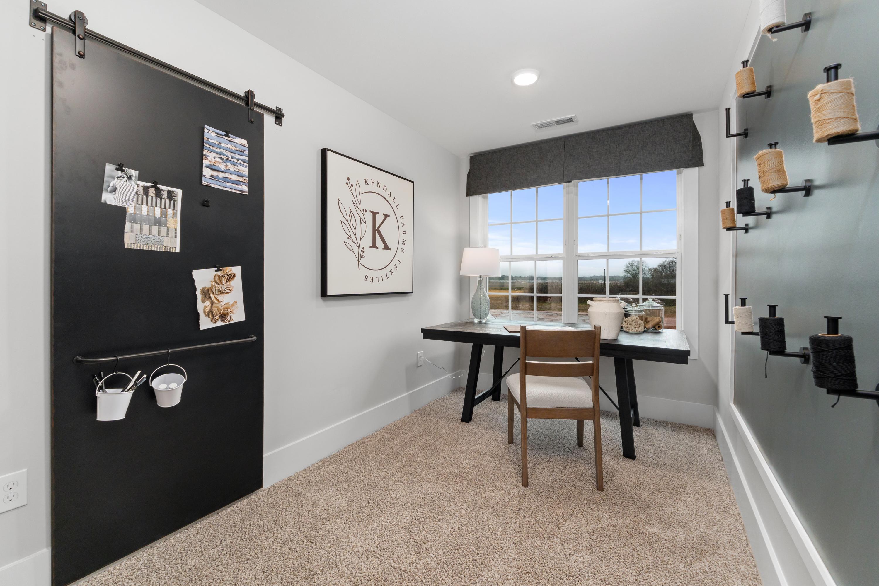 Cozy home office at Kendall Farms in Toney AL with sliding black barn door, wooden desk, chair, and large window view