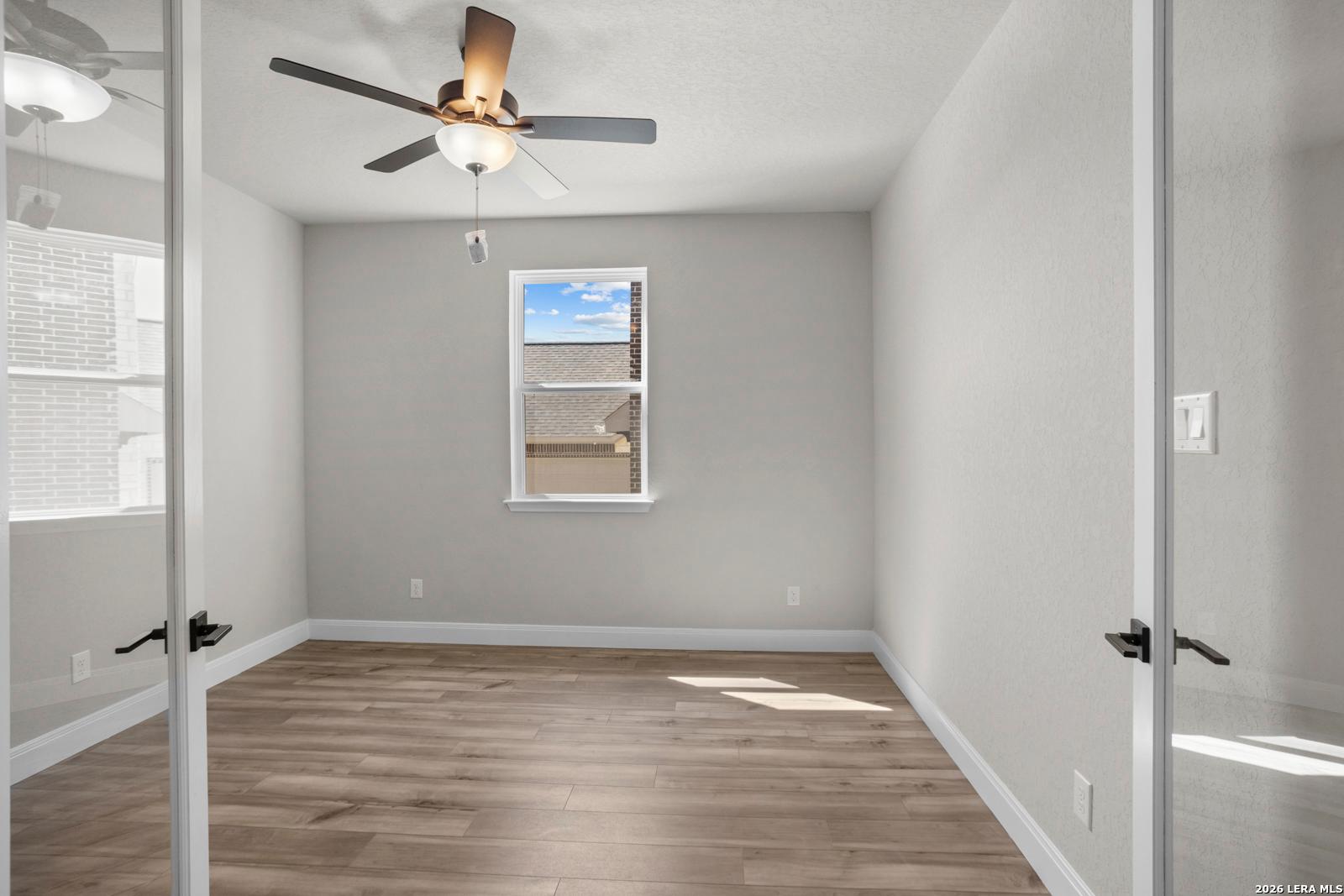 Bright home office with light wood floors and ceiling fan in The Jennings G floor plan by Davidson Homes in Ladera, TX.