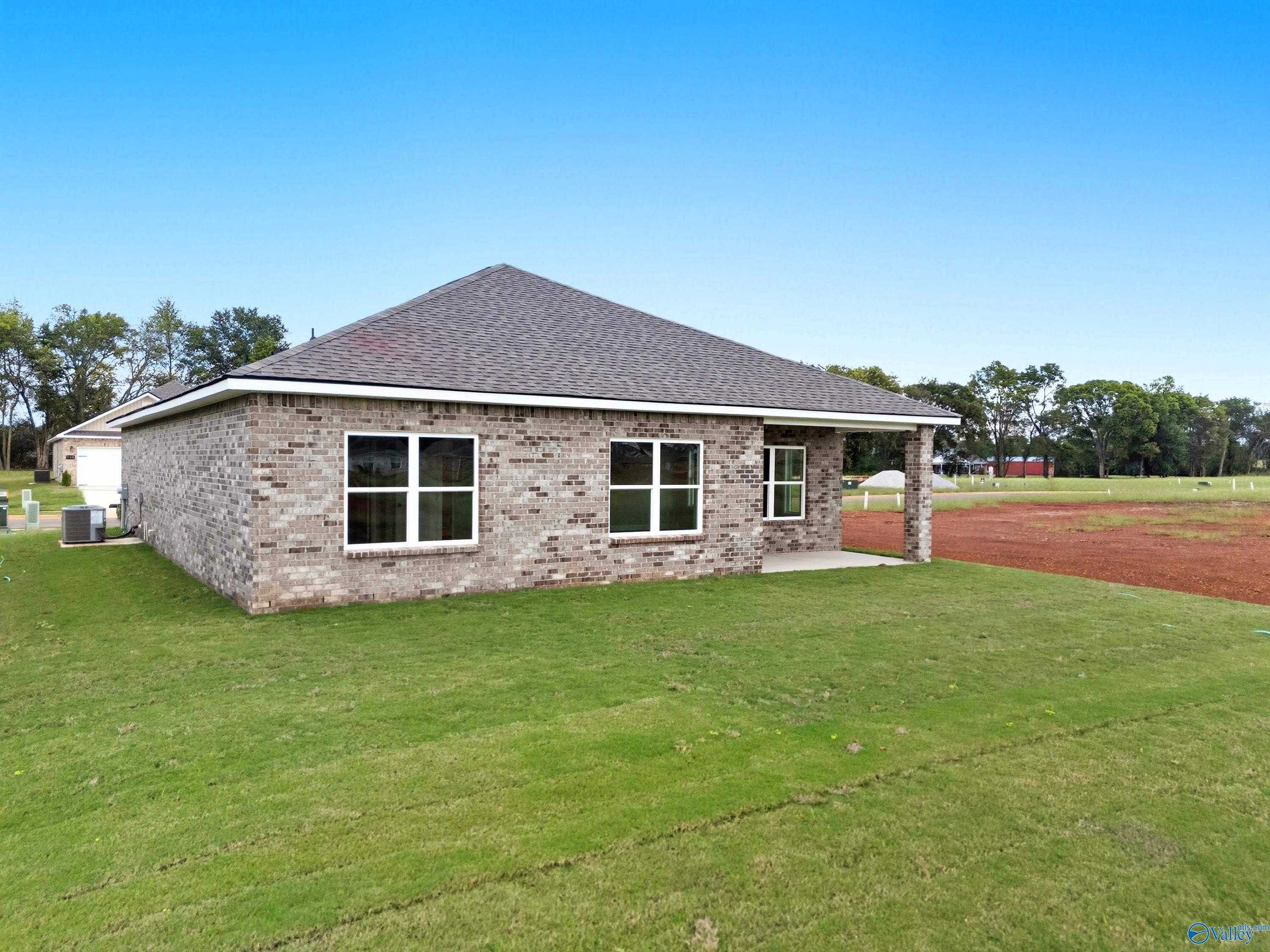Single-story brick home with attached 2-car garage and covered entry in lush green yard, The Franklin plan by Davidson Homes, Meridianville, AL