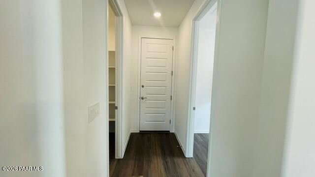 Hallway leading to a white door with an adjacent pantry in The Summit A floor plan at Westwood, Prescott, Arizona.
