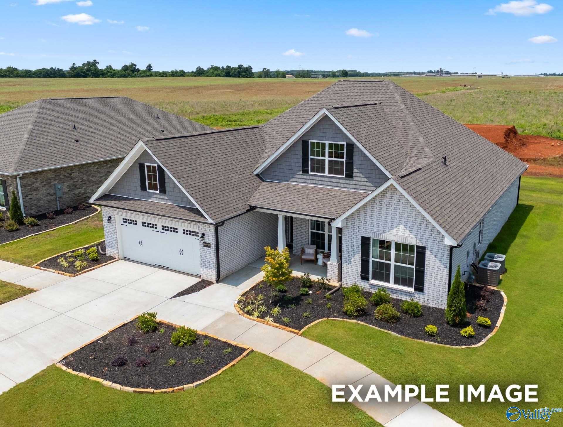 Aerial view of The Rockford B single-story white brick home with 2-car garage and landscaped yard in Cain Park, Hartselle, Alabama