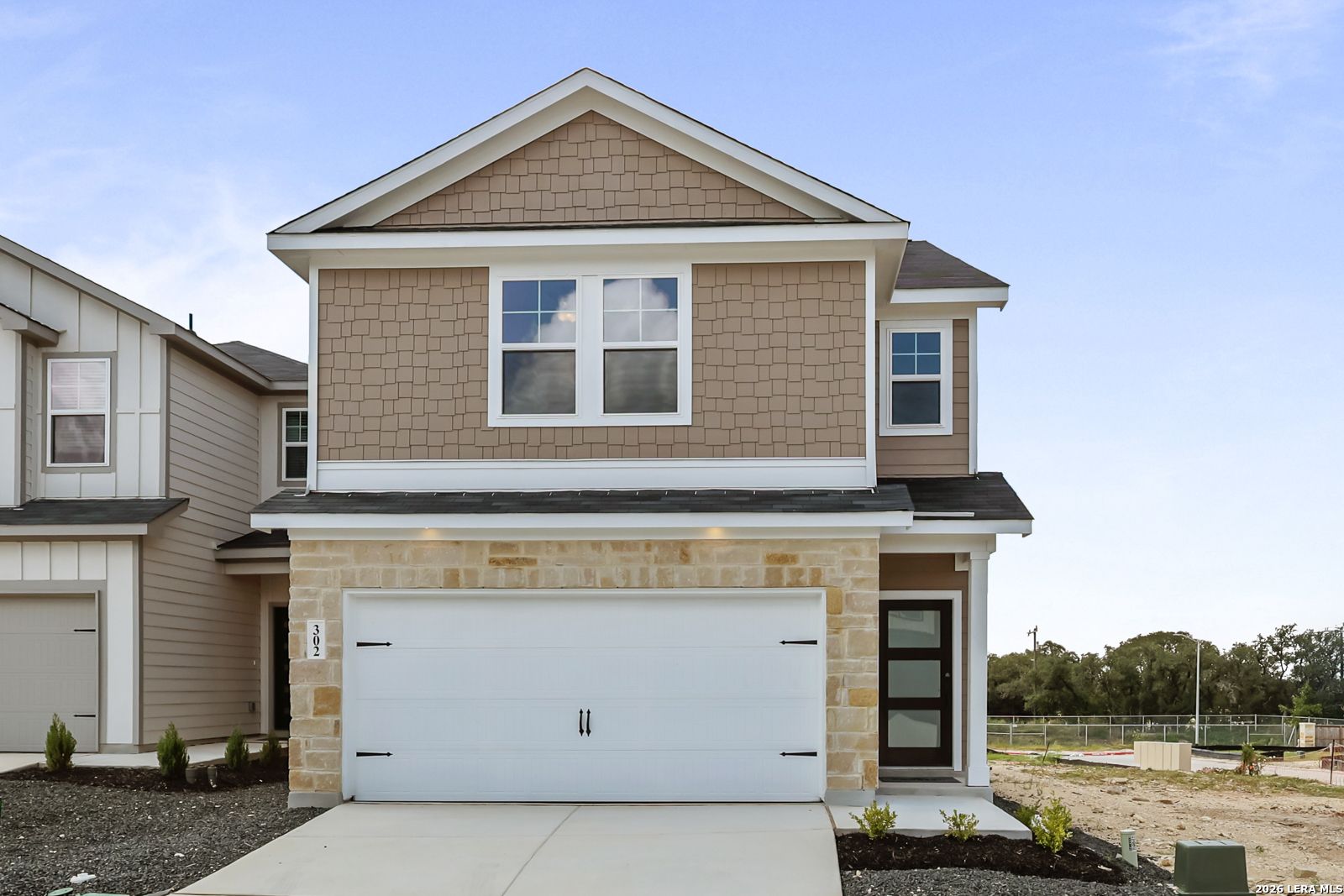 Two-story Florence B floor plan by Davidson Homes with stone facade and two-car garage in Meadows at Oak Creek, San Antonio.