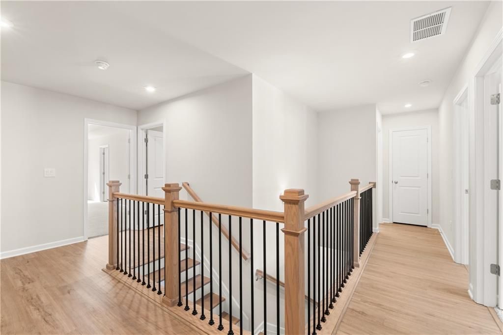 Elegant oak staircase with black balusters in second-floor hallway of The Marion B 3-bedroom home, Kennesaw, Georgia