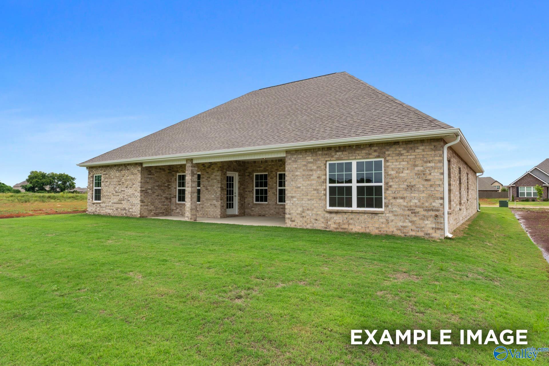 Two-story brick home with covered front porch and lush green yard in Kendall Farms, Toney, Alabama