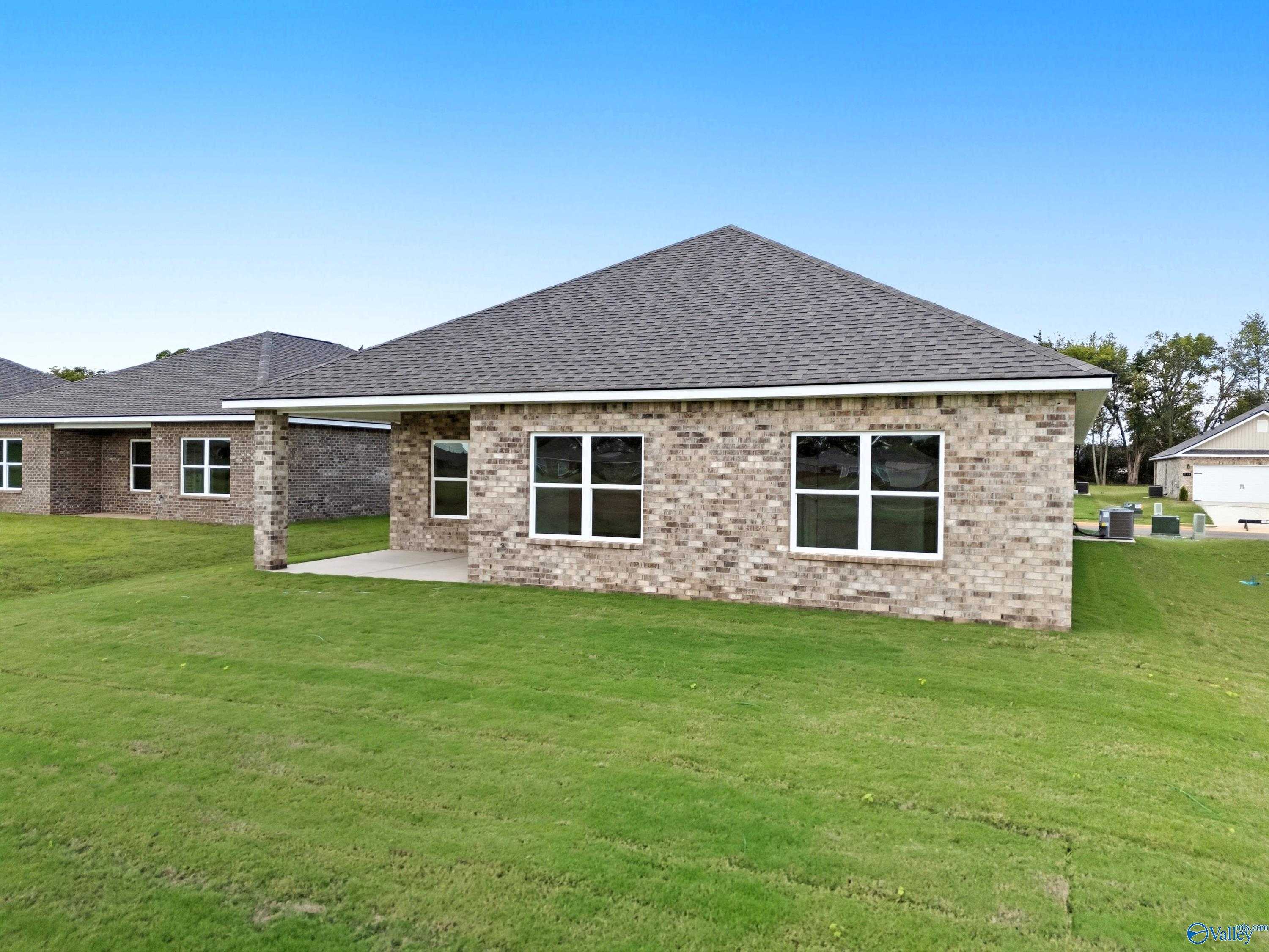 Single-story brick home with 2-car garage, gabled roof, and green lawn in Lynn Meadows, Meridianville, Alabama