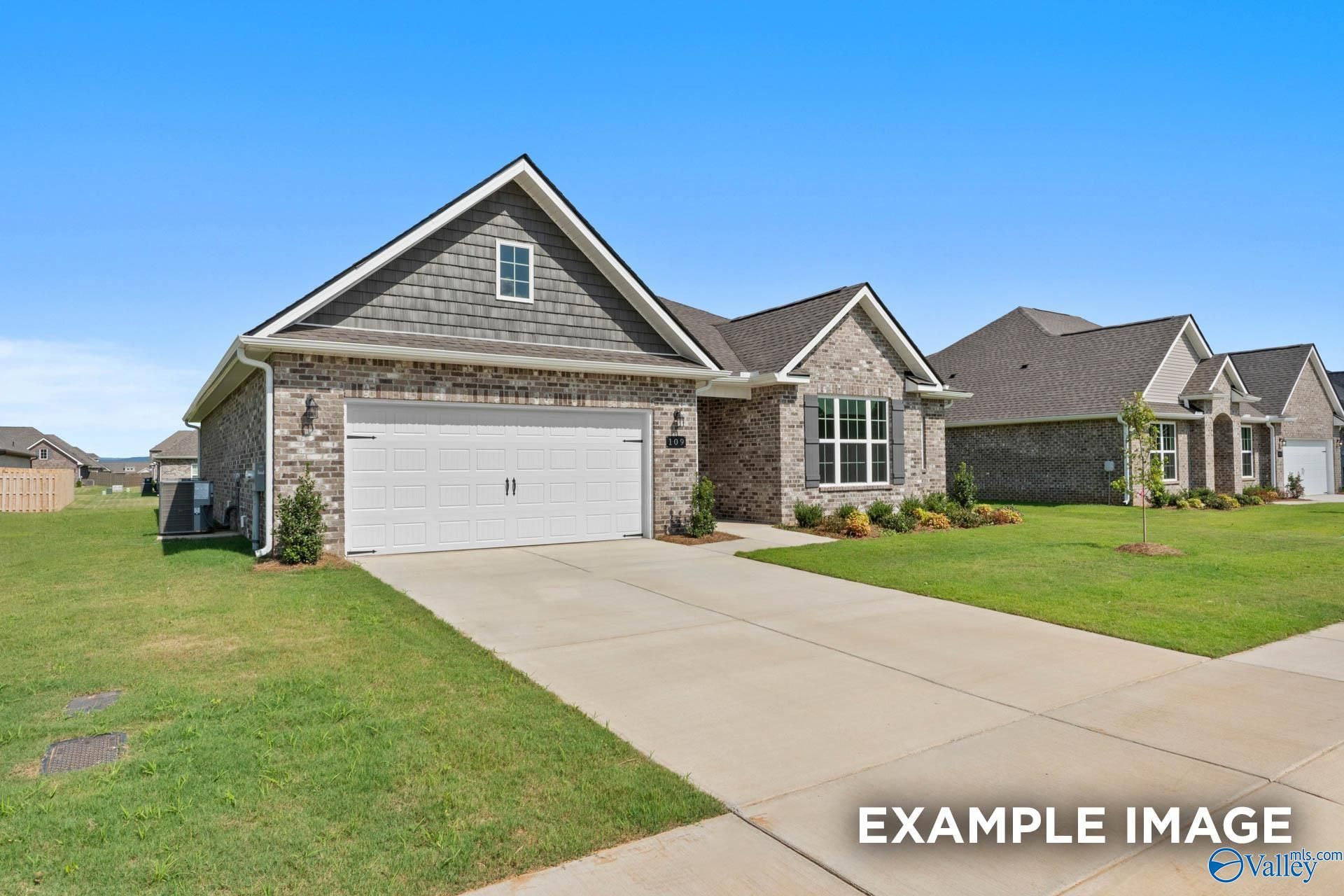Modern 3-bedroom single-story home with gray siding, brick accents, 2-car garage, and lush lawn in Cain Park, Hartselle, Alabama