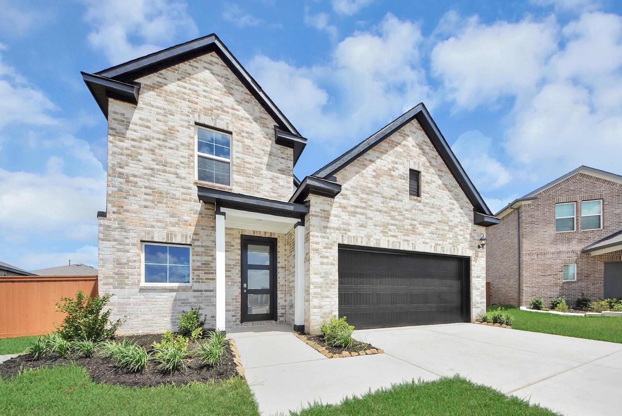 Two-story Davidson Homes Verano B floor plan with brick exterior and two-car garage in Sunterra, Katy, Texas.