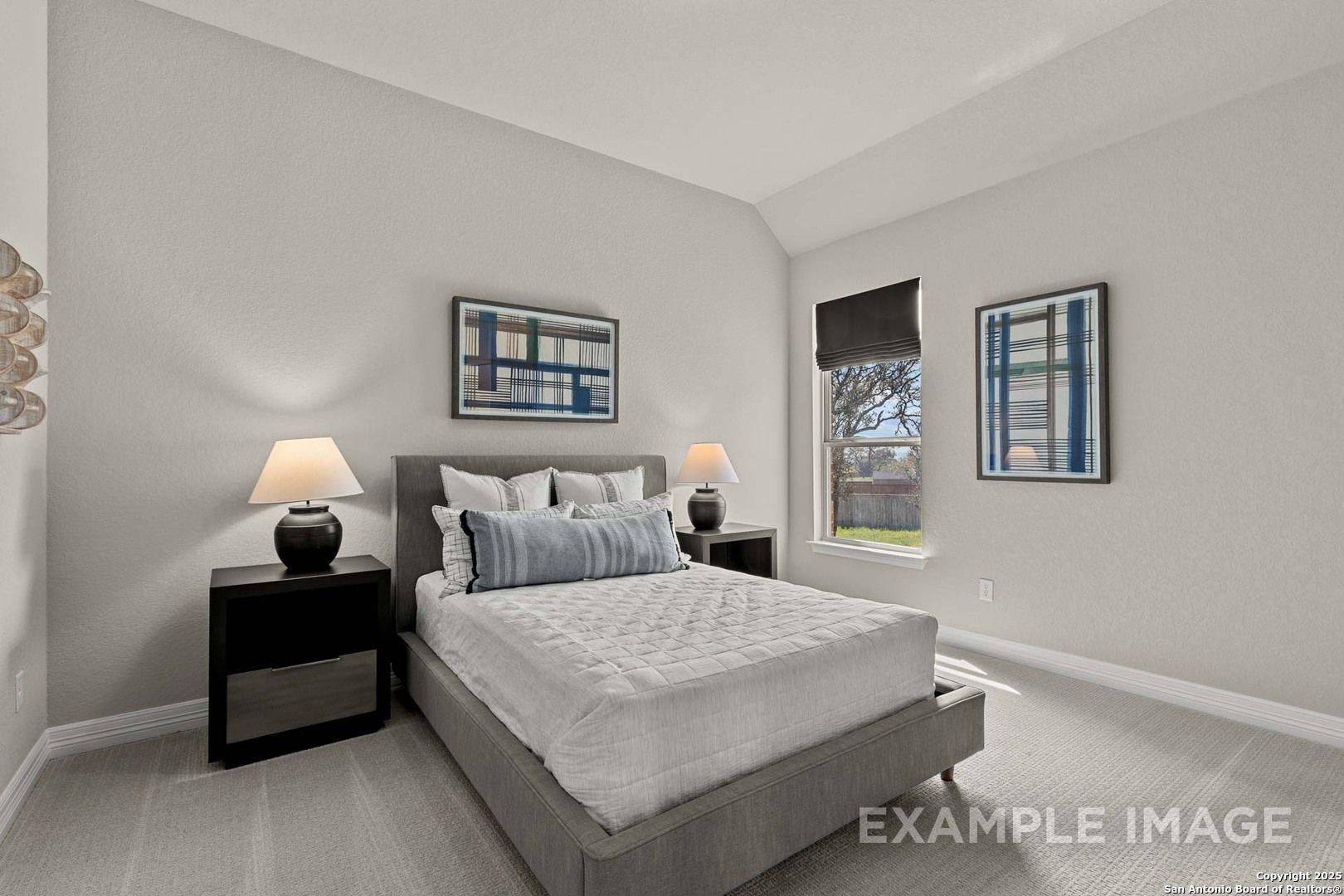 Tranquil master bedroom with gray platform bed, blue pillows, abstract art, and tree-view window in Davidson Homes The Summerlin B, Castroville
