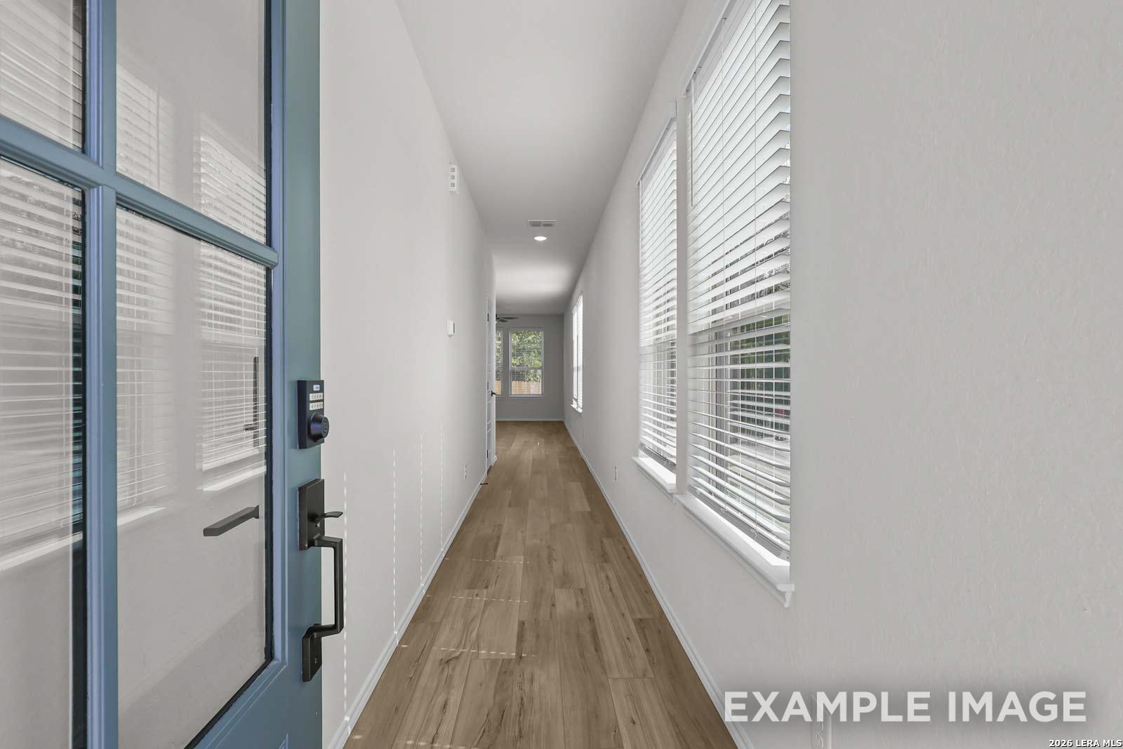 Bright entryway hallway with wood-look flooring and natural light in The Florence D floor plan, Cedar Heights, San Antonio.