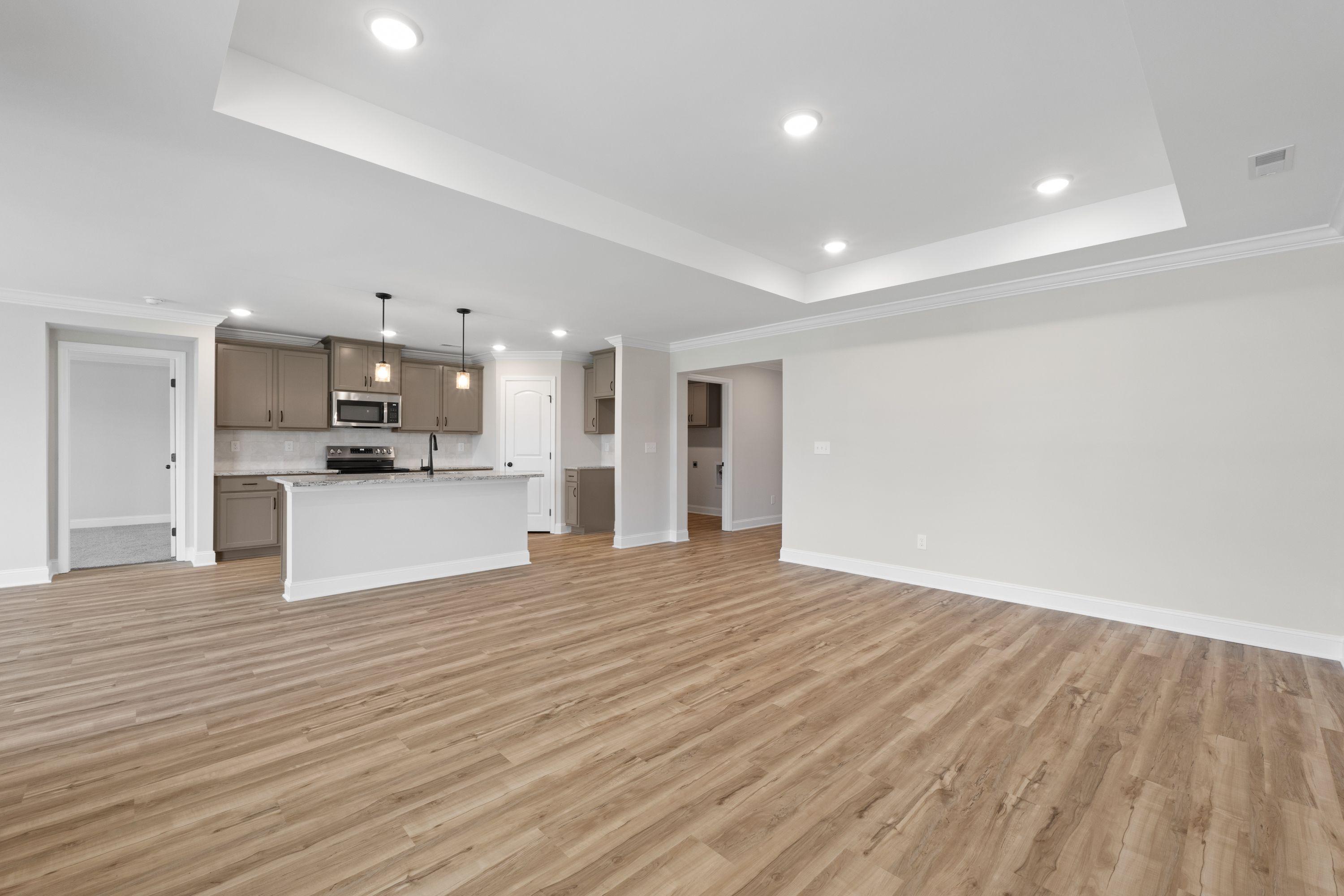 Open-concept living area and kitchen with tray ceiling in The Holly C floor plan by Davidson Homes.