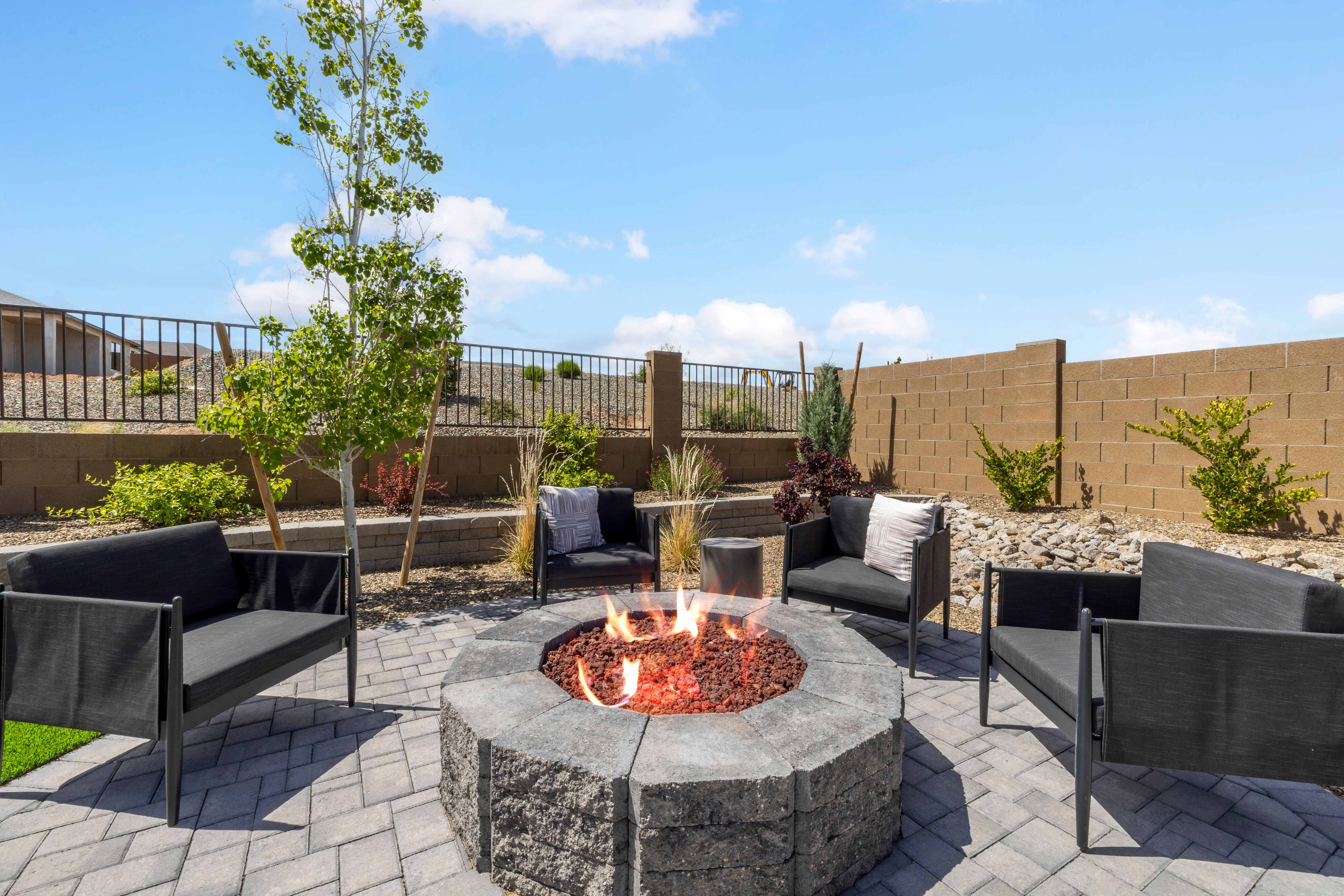Cozy outdoor fire pit with modern black seating at South Ranch Western Collection in Prescott AZ, paver patio and desert landscaping