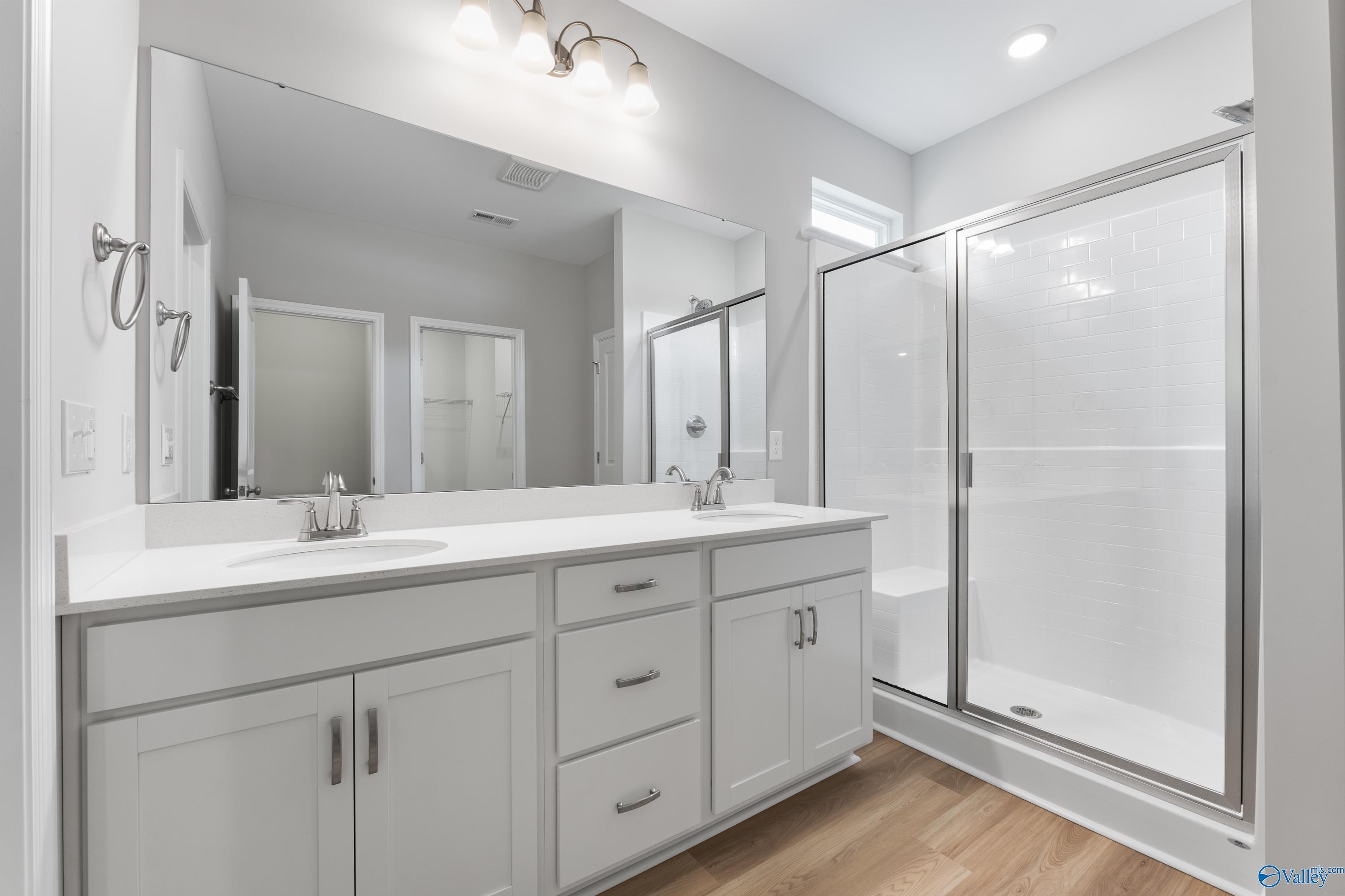 Modern master bath with double white vanity, frameless glass shower, soaking tub in Davidson Homes The Phoenix, Hazel Green, Alabama