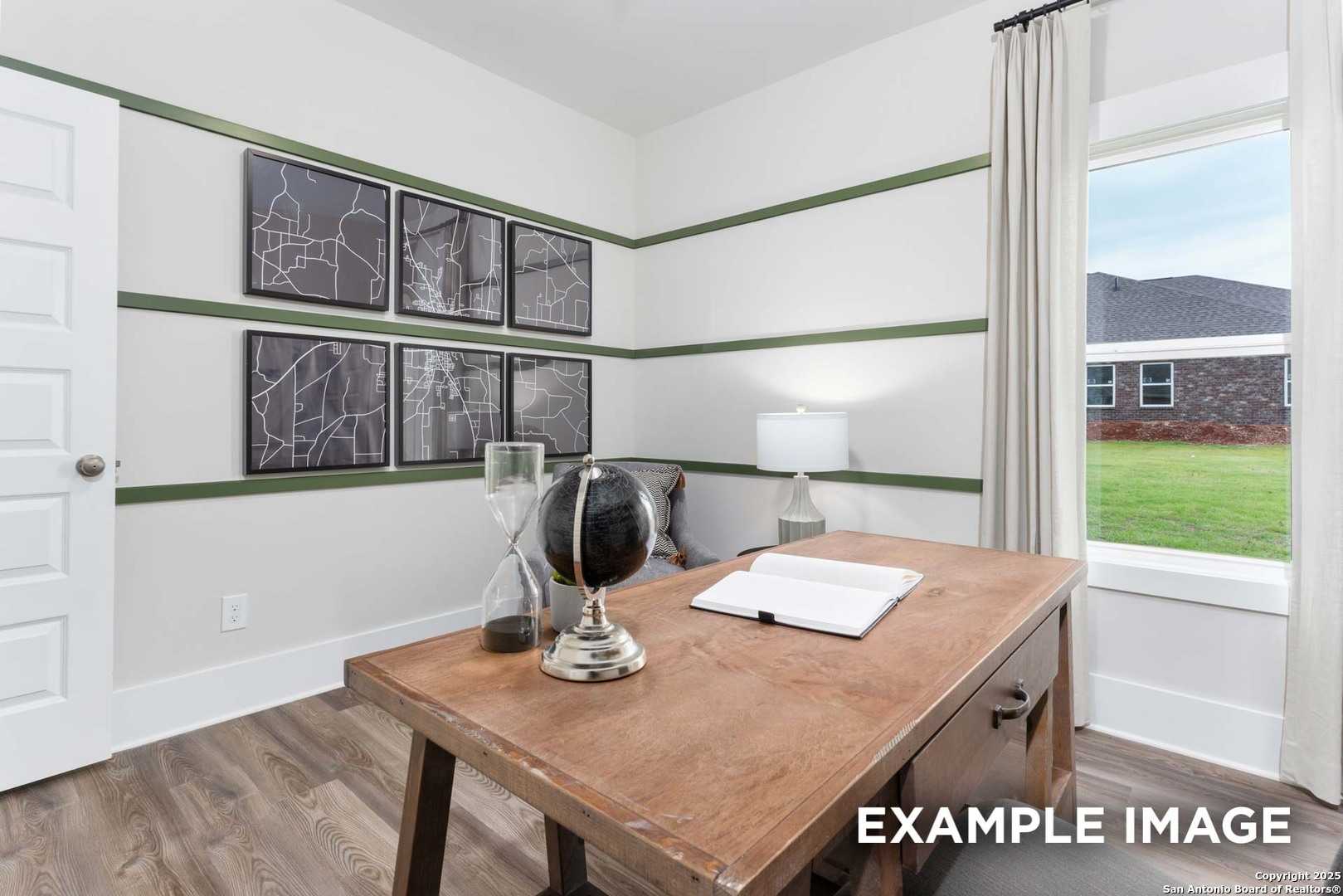 Cozy home office with wooden desk, open notebook, globe decor, and backyard view in Davidson Homes The Daphne H, Seguin, Texas