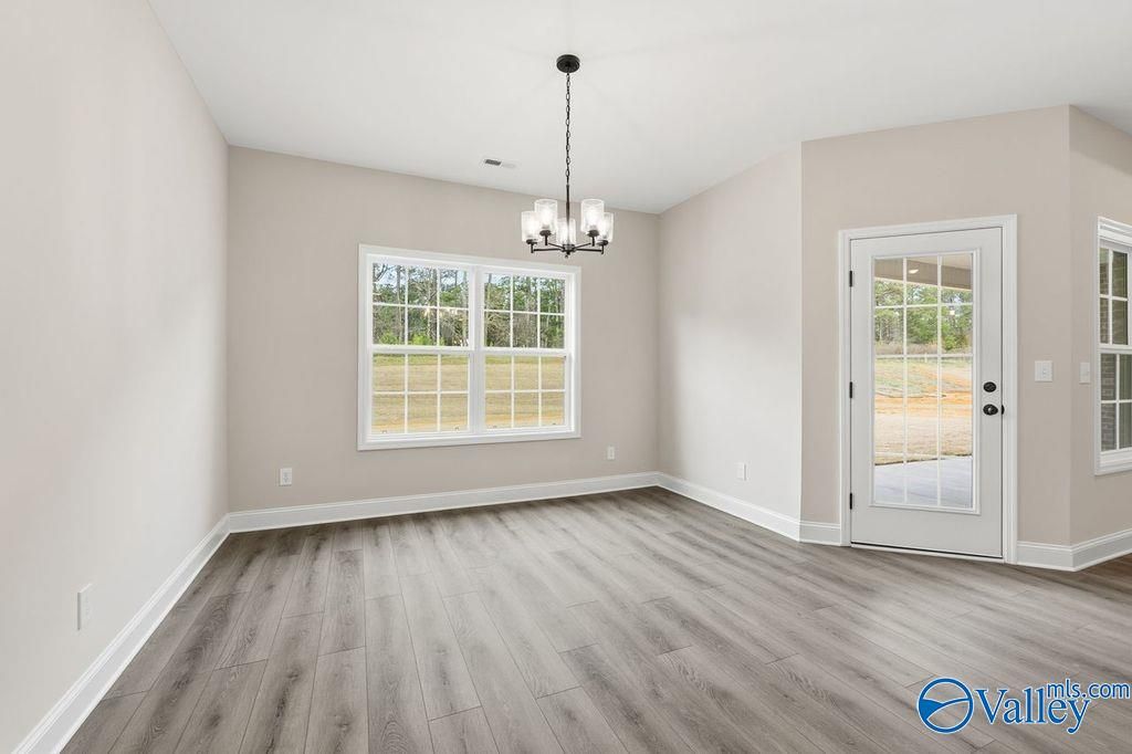 Bright dining room with chandelier, large windows, and patio door in Davidson Homes The Rockford B, Hartselle, Alabama