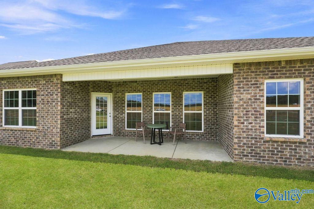 Covered brick patio with seating area on Davidson Homes' The Harrison plan in Cain Park, Hartselle, Alabama