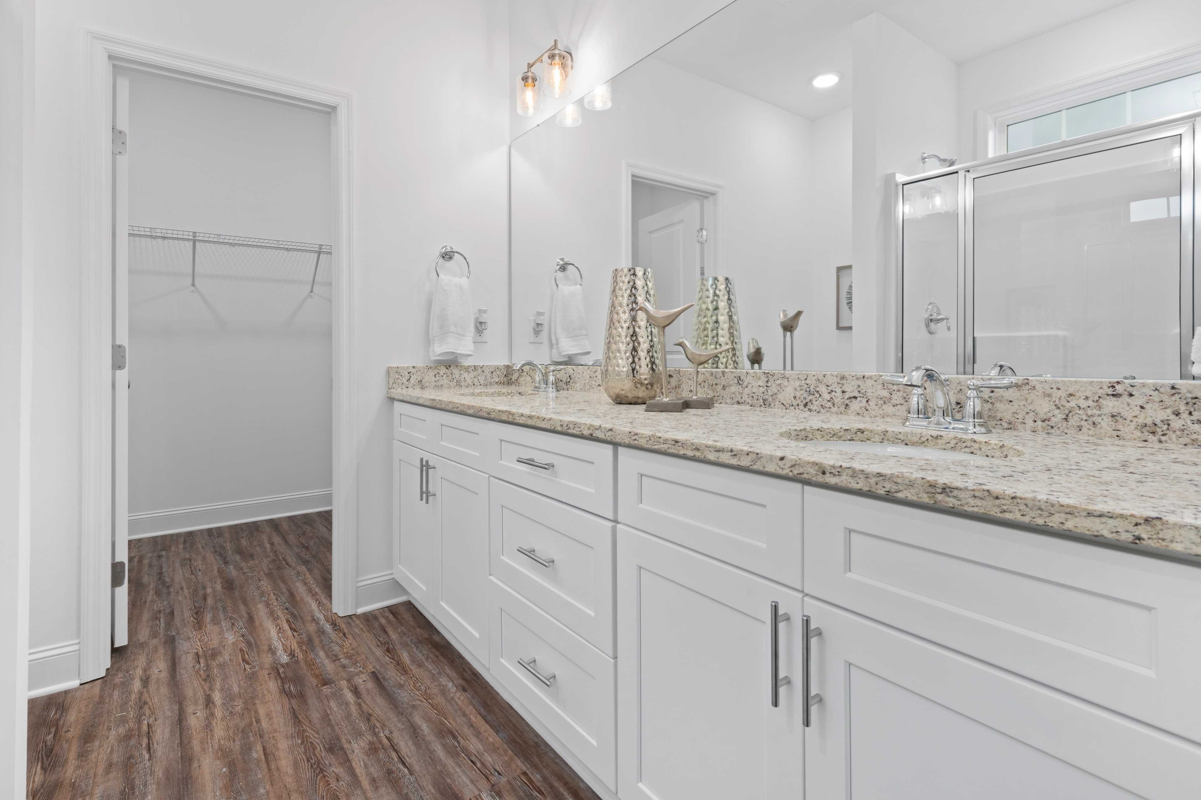 Spacious master bathroom at The Retreat at Hollon Meadow in Decatur AL with double vanity, white shaker cabinets, quartz counters, and glass shower