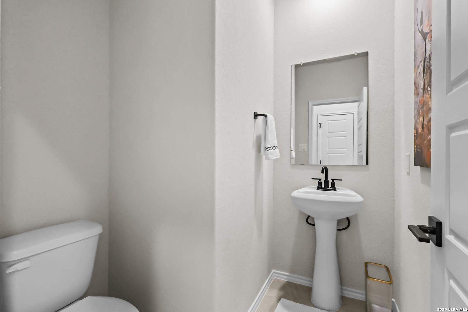Modern powder room with pedestal sink in The Douglas C floor plan at Hannah Heights, Seguin, Texas.