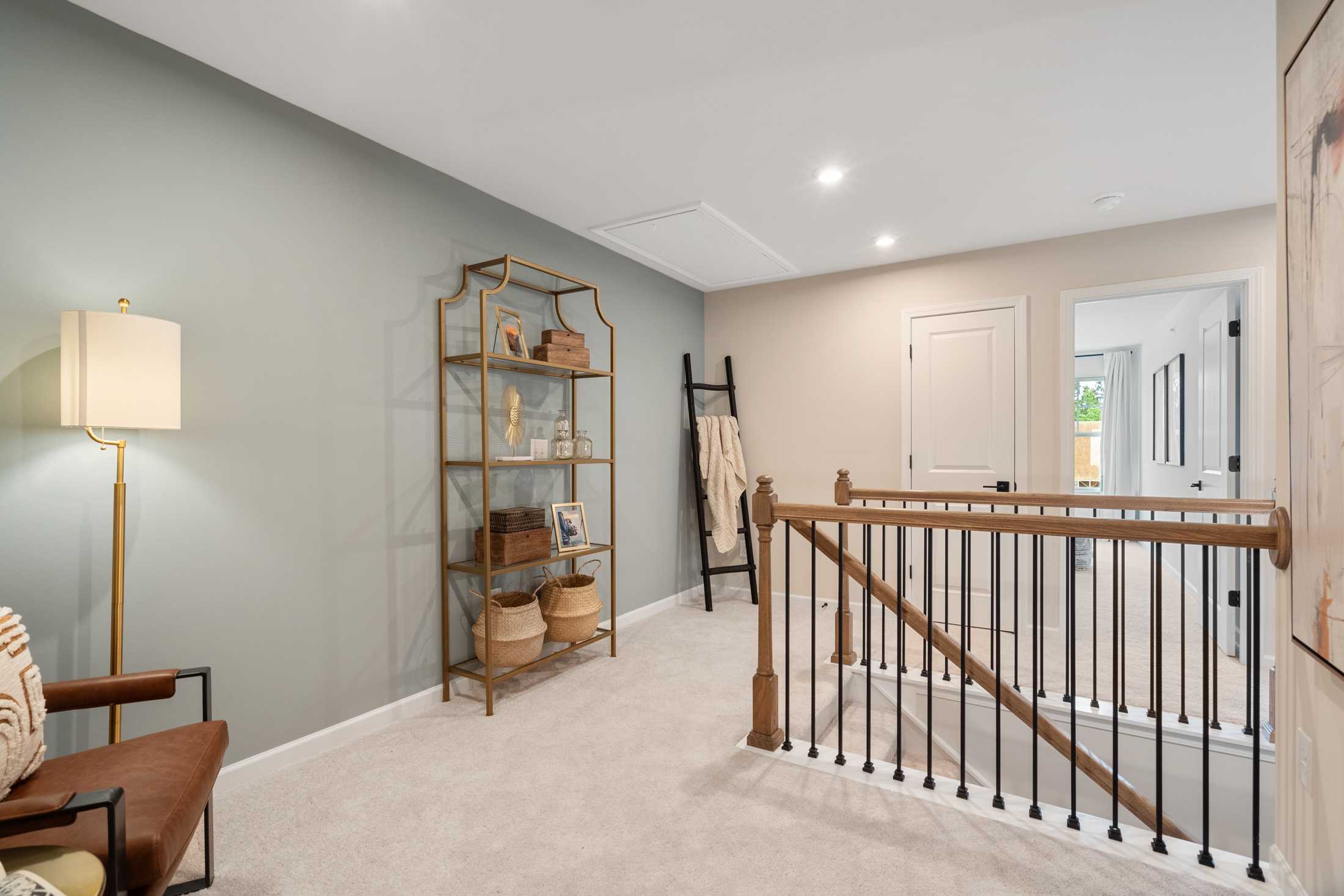 Cozy upstairs loft at Rosehill Townhomes in Marietta GA with wooden staircase, gold bookshelf, floor lamp and armchair
