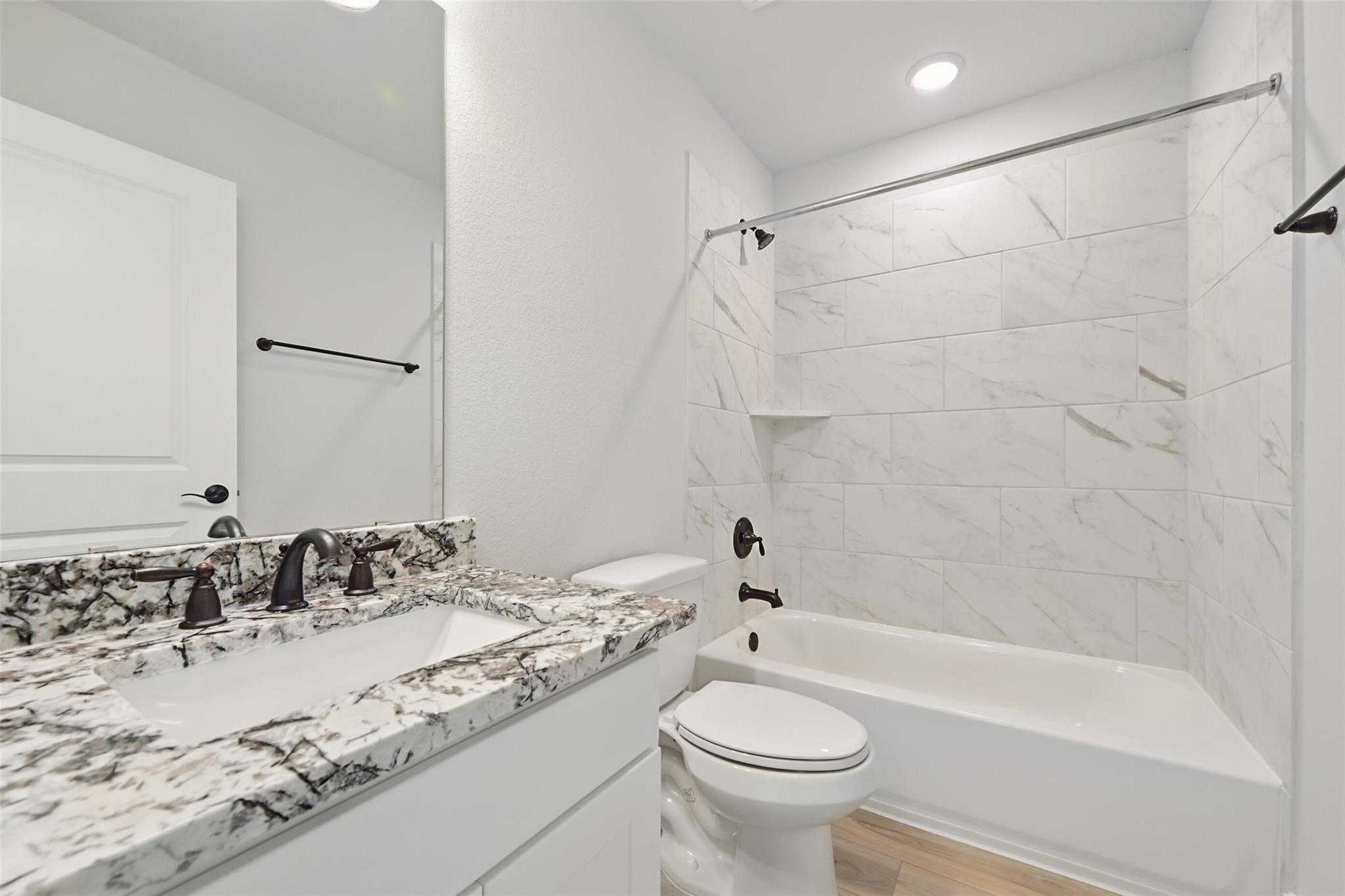 Modern spa bathroom with white marble shower, freestanding tub, double vanity in Davidson Homes The Victoria C, Lago Mar Texas City