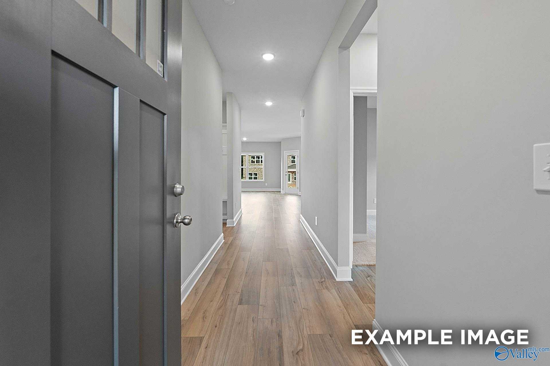 Welcoming entry hallway with hardwood floors, white walls, and recessed lighting in The Franklin E 3-bedroom home, Hazel Green, Alabama