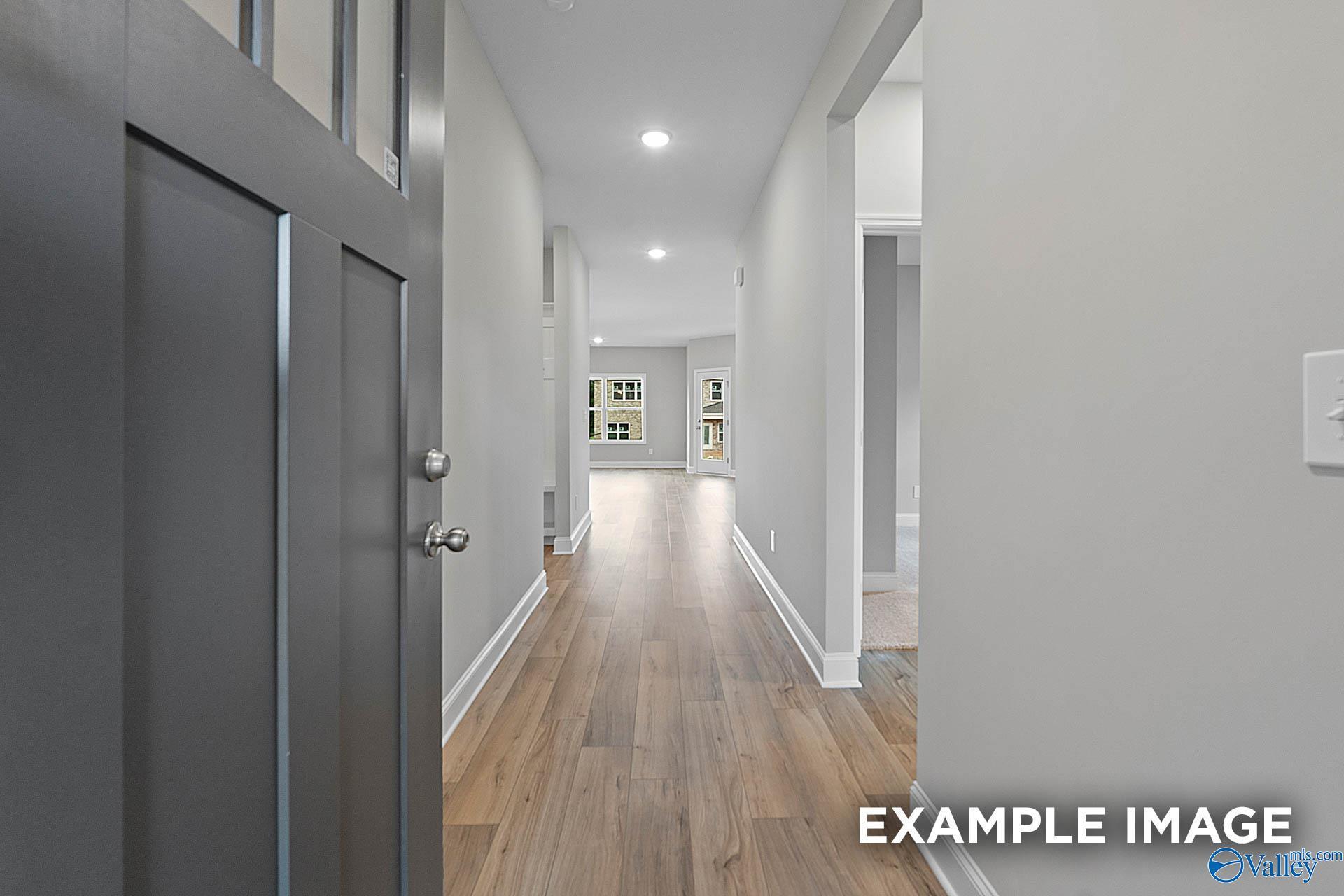 Welcoming entry hallway with hardwood floors, white walls, and recessed lighting in The Franklin E 3-bedroom home, Hazel Green, Alabama