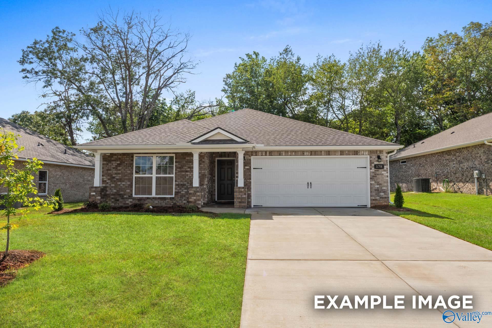 Modern brick single-story home with 2-car garage, covered porch, and lush lawn in Clearview, Hazel Green, Alabama by Davidson Homes The Asheville B