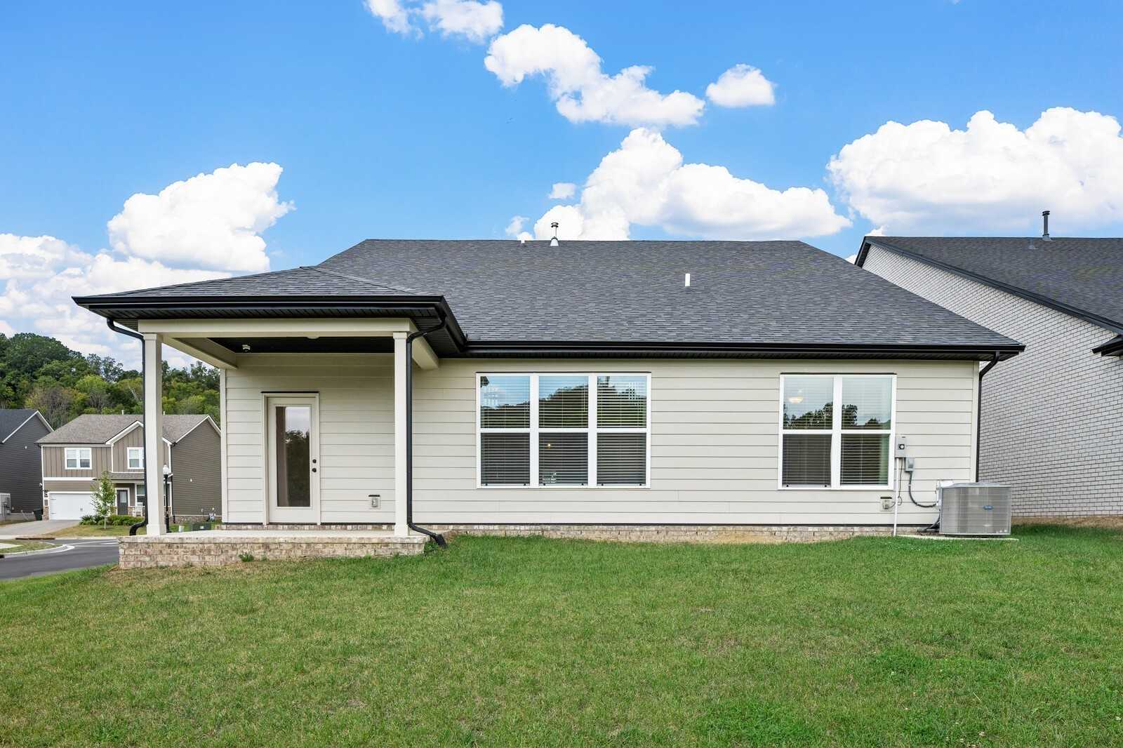 Modern two-story Ridgeport home exterior with covered front porch, large windows, and lush green lawn in Carellton, Gallatin, Tennessee