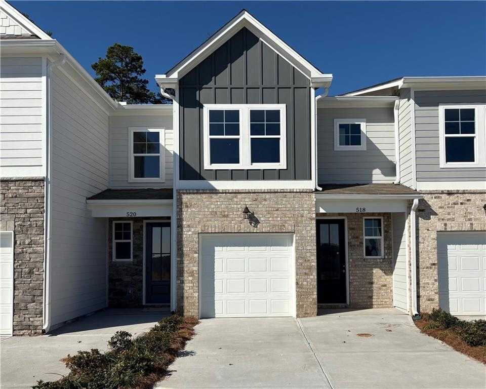 Modern two-story Durant C townhome exterior with gray shiplap siding, brick base, white garage, and driveway in Stegall Village, Emerson, Georgia