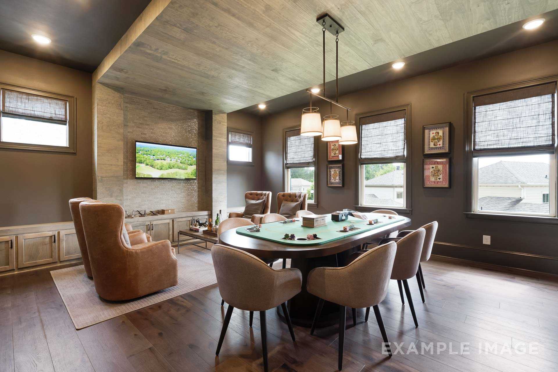 Spacious game room in The Seaside A with green felt poker table, leather armchairs, mounted TV, and wooden beamed ceiling