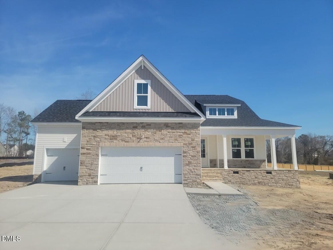 Two-story Davidson Homes Cypress B II with stone accents, three-car garage, and covered porch in Tobacco Road, Angier, NC
