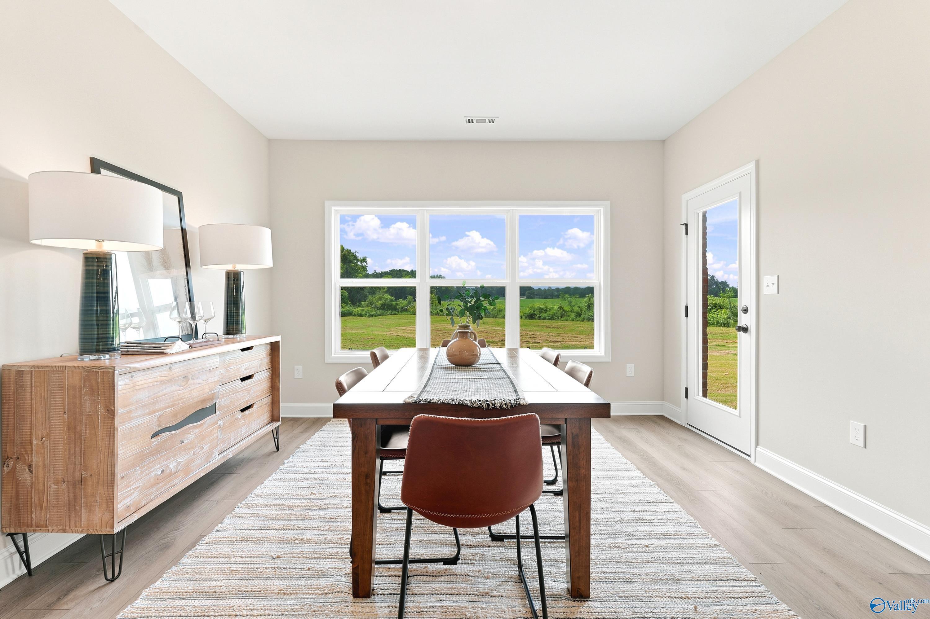 Bright dining room with wooden table and scenic backyard views in The Finleigh floor plan, Riverton Preserve, Huntsville.