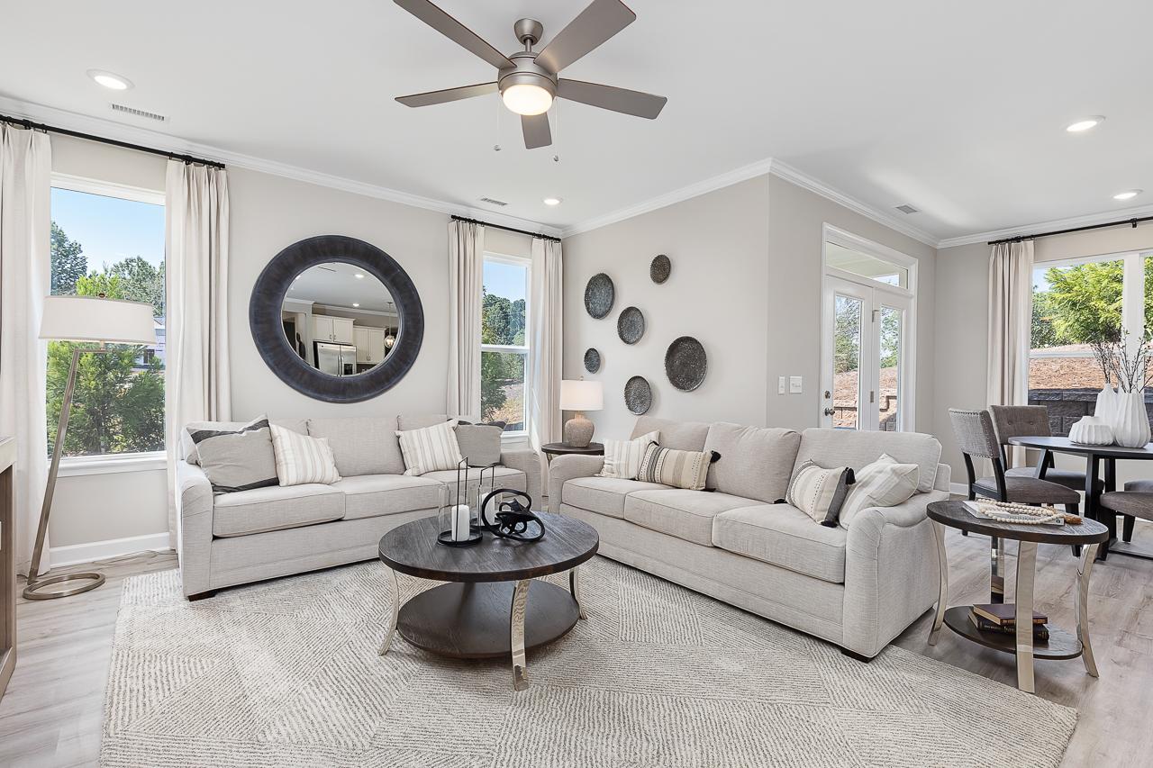 Modern living room at Woodland Crossing in Zebulon, NC, featuring neutral furniture, a round coffee table, and decor.
