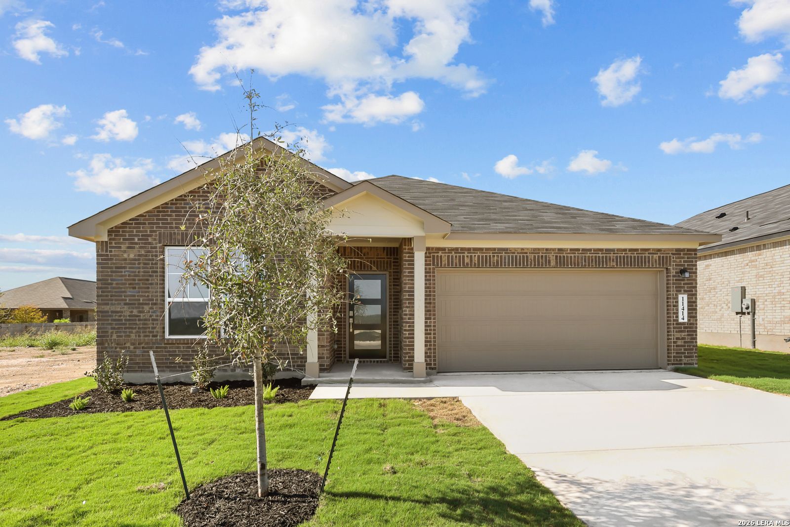Brick exterior front elevation of The Daphne I, a 1-story 4-bedroom home with 2-car garage in Bricewood, San Antonio, Texas.