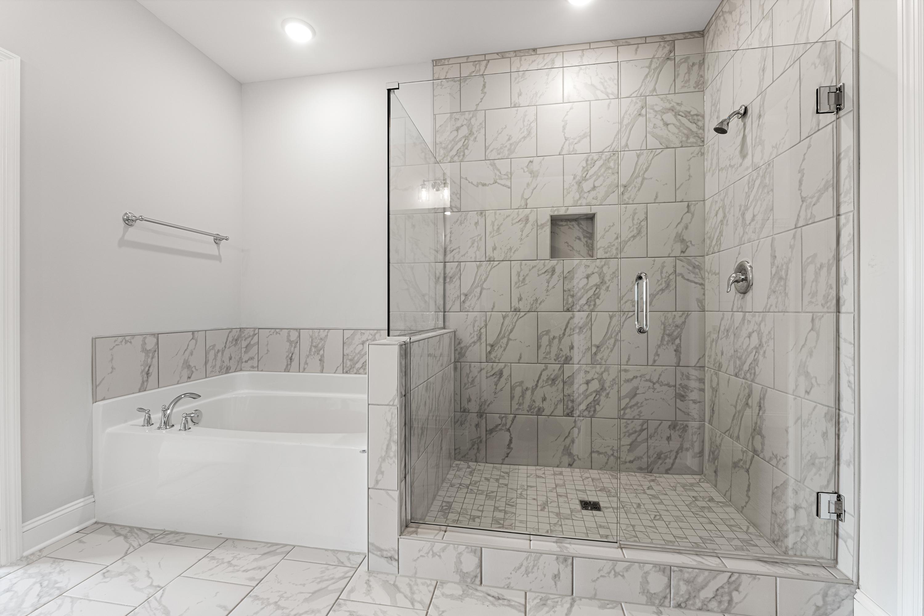 Spacious master bathroom in The Copeland C featuring freestanding tub and glass-enclosed marble shower