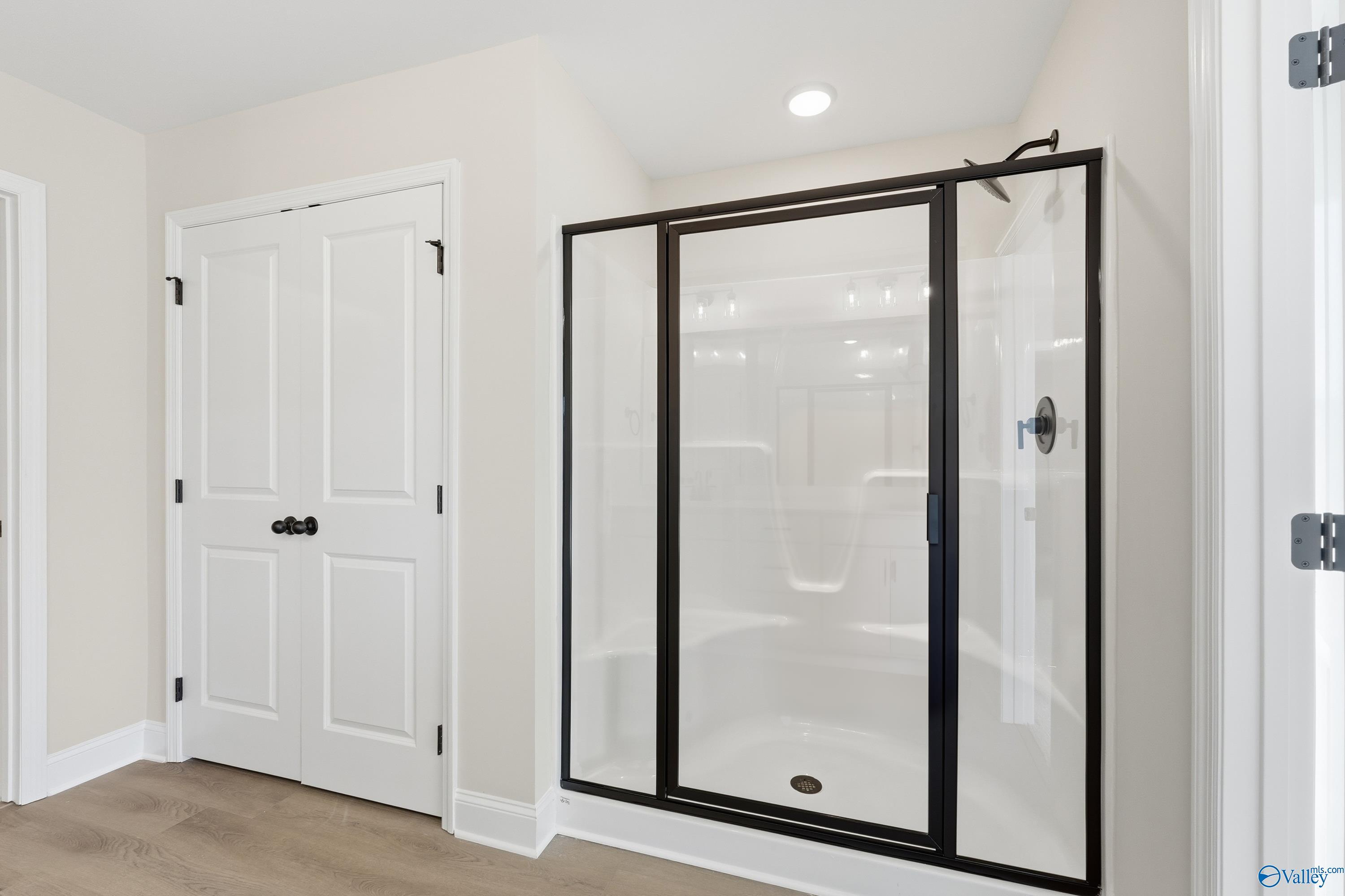 Modern frameless glass shower with bench seat in master bath of Davidson Homes The Chelsea C, Creekside, Harvest, AL