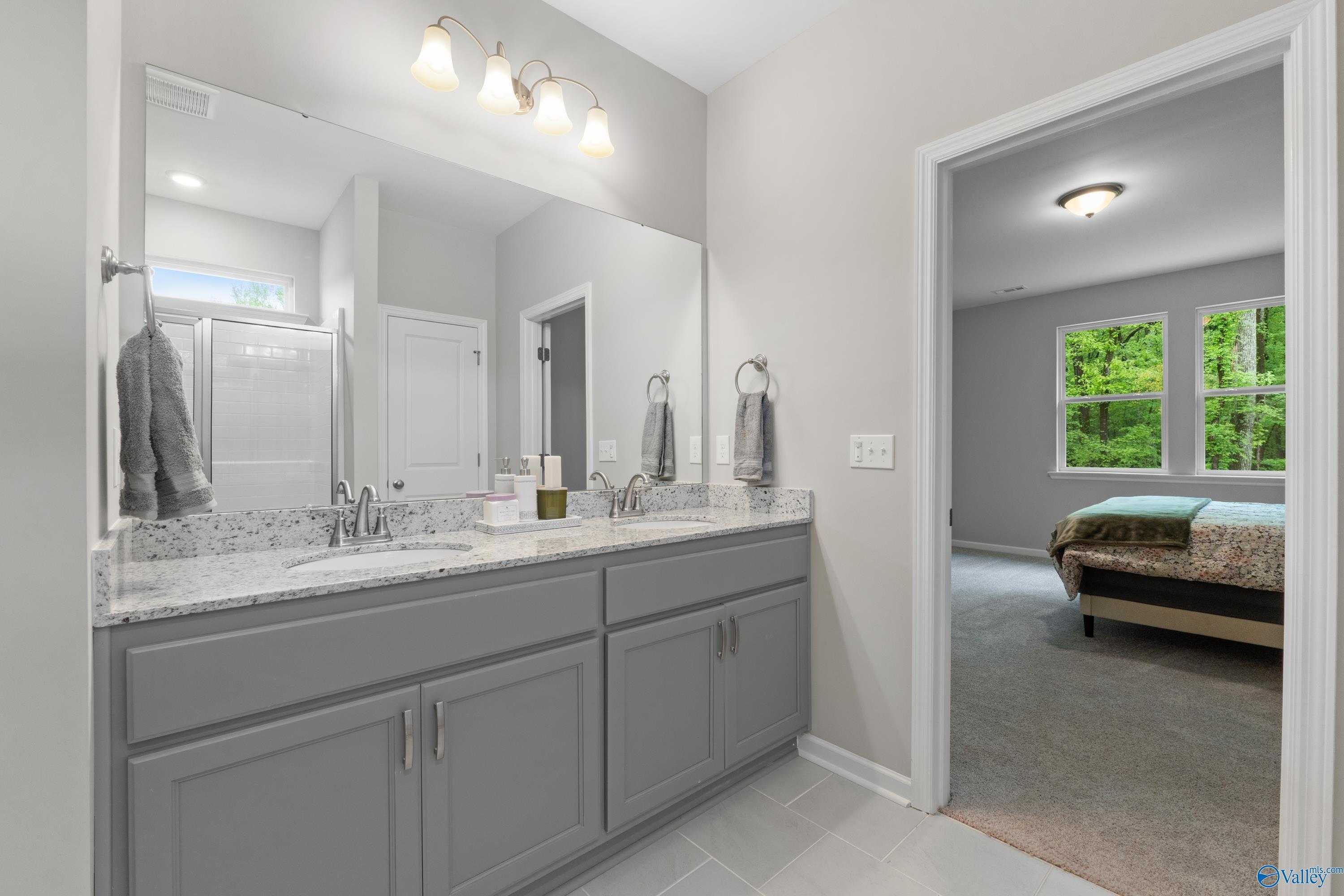 Modern double vanity with gray cabinets, quartz counters, and mirrors in The Luna master bath, Davidson Homes, Hazel Green, Alabama