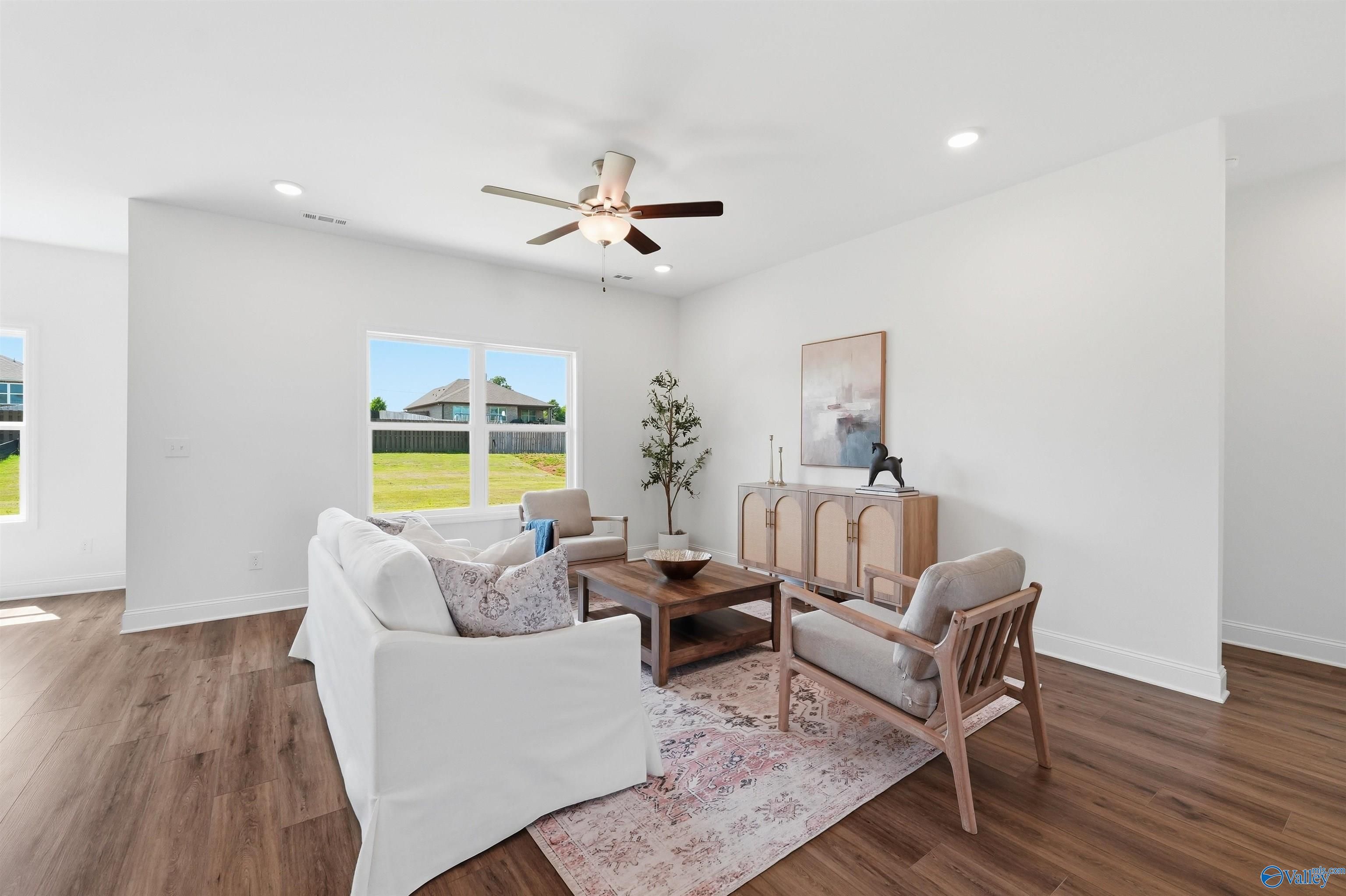 Bright, open-concept living room with wood-style flooring in The Franklin C floor plan at Lynn Meadows, Meridianville.