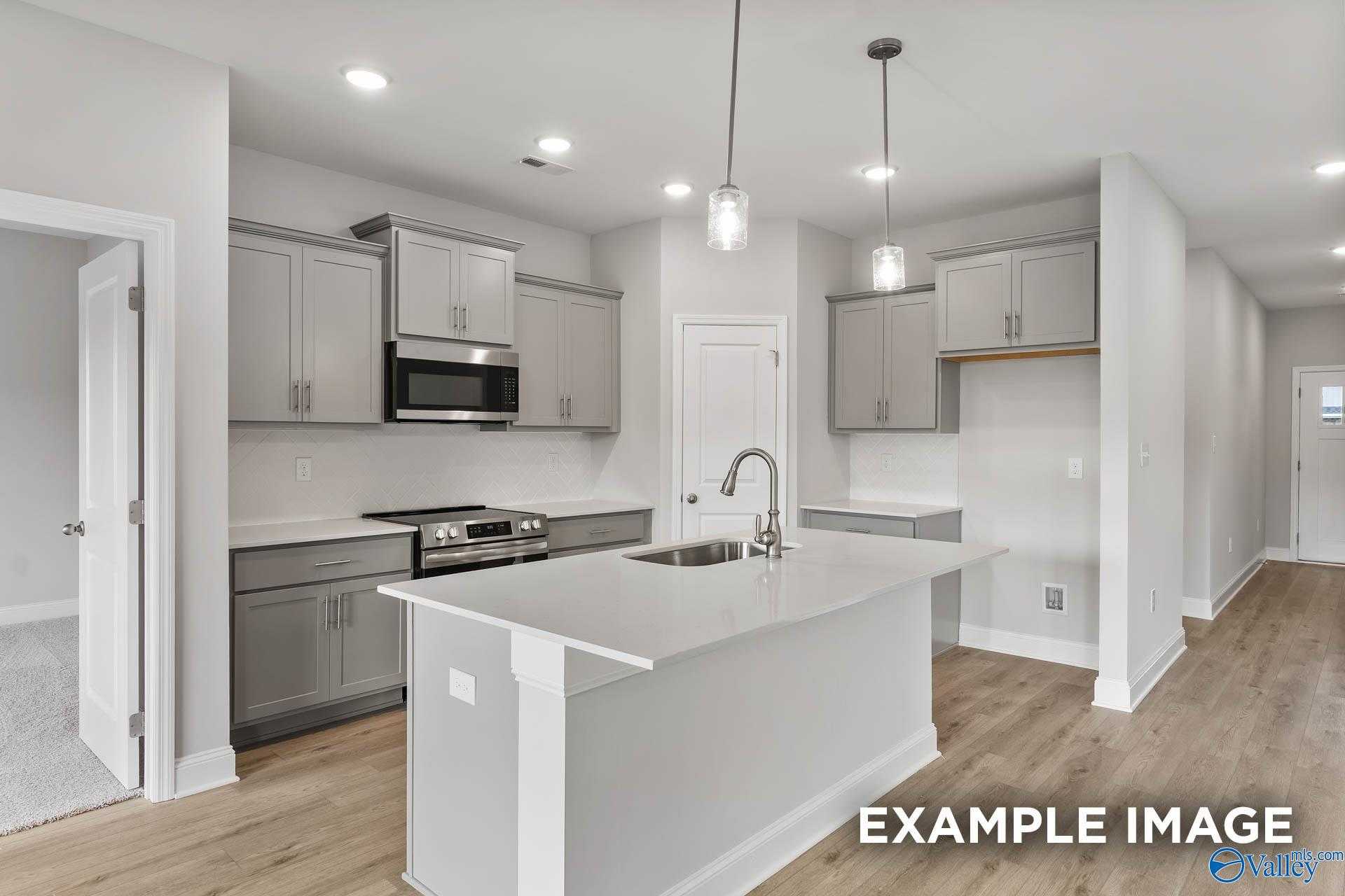 Modern open-concept kitchen with shaker cabinets, stainless appliances, and center island in Davidson Homes The Franklin C, Athens, Alabama