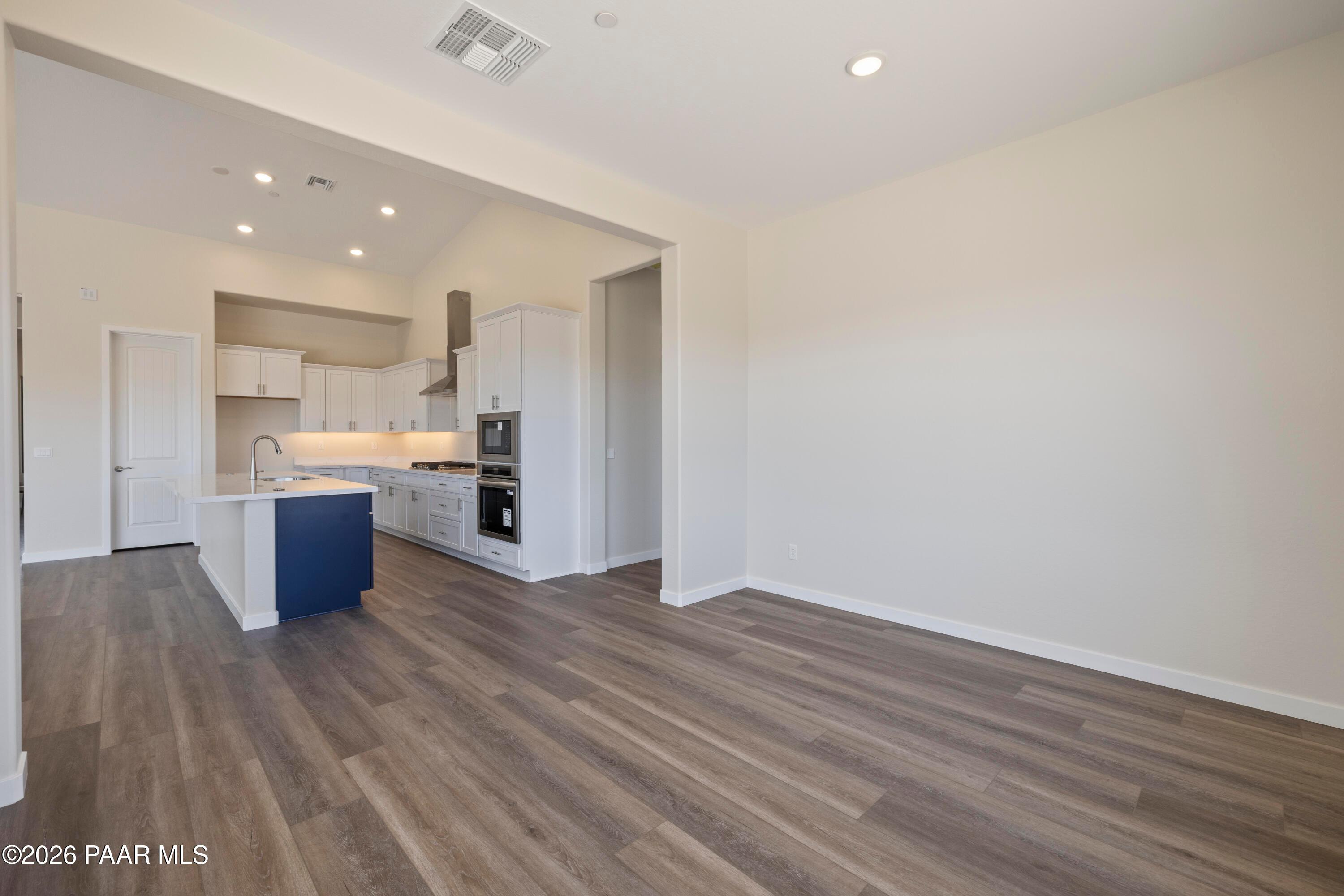 Open-concept kitchen with white cabinets, navy island, stainless appliances in Davidson Homes The Soleil E, Prescott, AZ