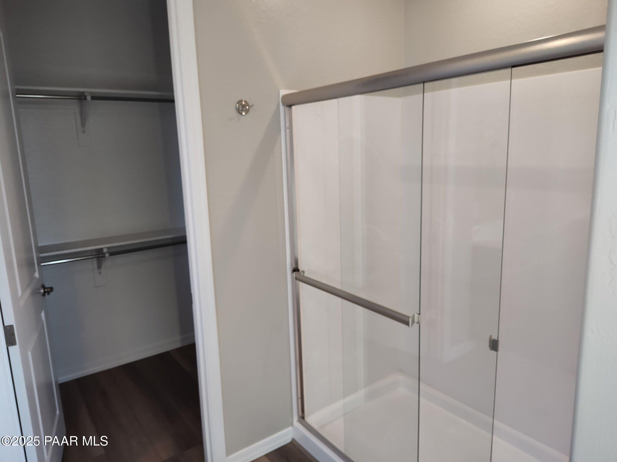 Modern master bathroom with frameless glass walk-in shower and adjacent closet in Davidson Homes The Frontier C, Prescott Valley, AZ
