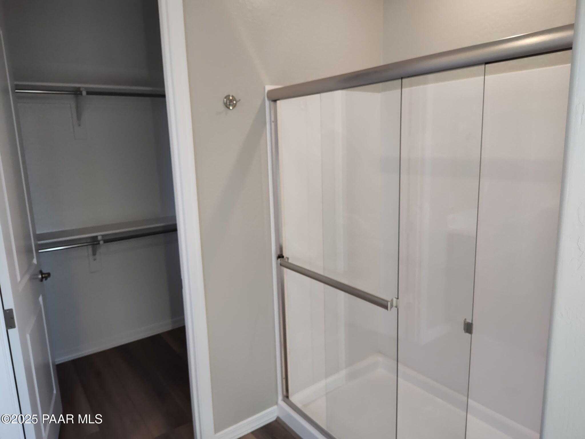 Modern master bathroom with frameless glass walk-in shower and adjacent closet in Davidson Homes The Frontier C, Prescott Valley, AZ