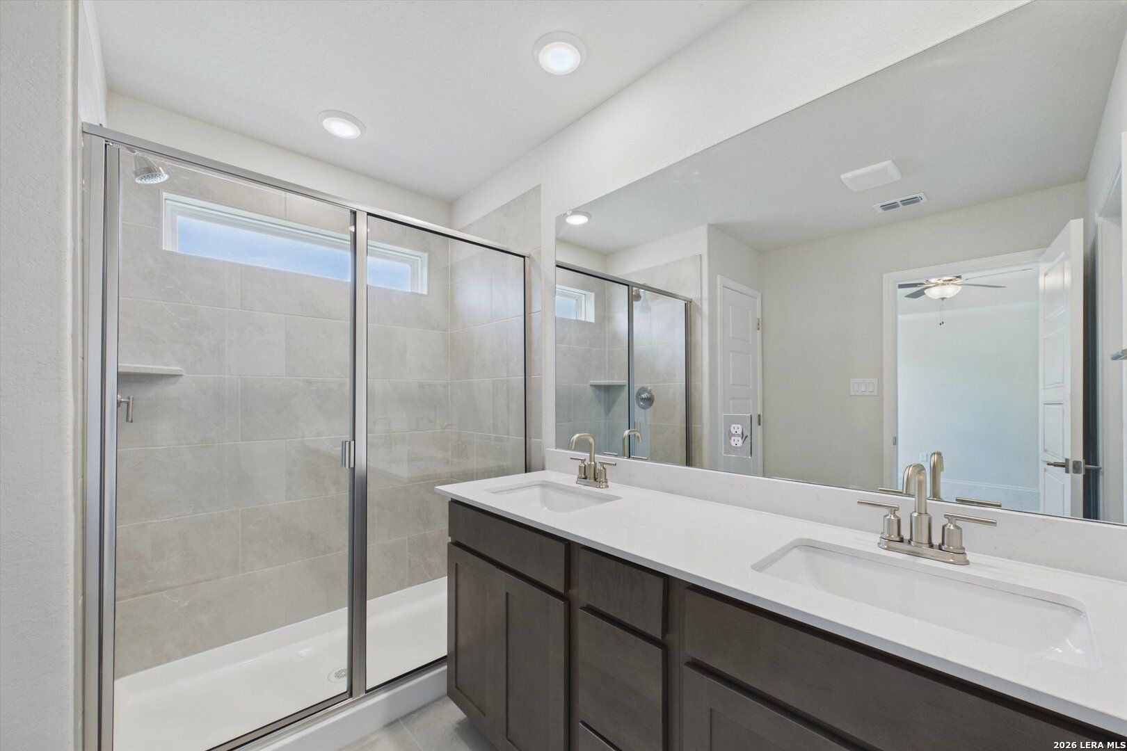 Modern bathroom with double vanity and walk-in glass shower in The Charlotte B floor plan at Meadows at Oak Creek.