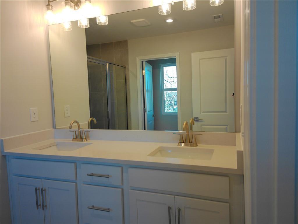 Modern master bathroom featuring double vanity with gold faucets and walk-in shower in Davidson Homes The Marion C, Winder, Georgia