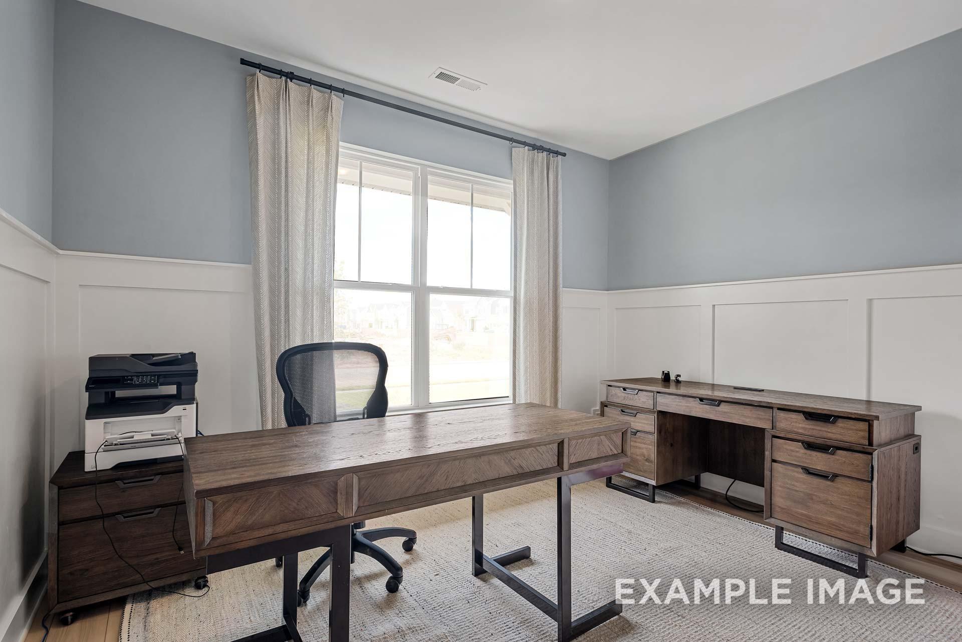 Modern home office with wooden L-shaped desk, ergonomic chair, and large window in Davidson Homes The Ridgeport C, Gallatin, Tennessee